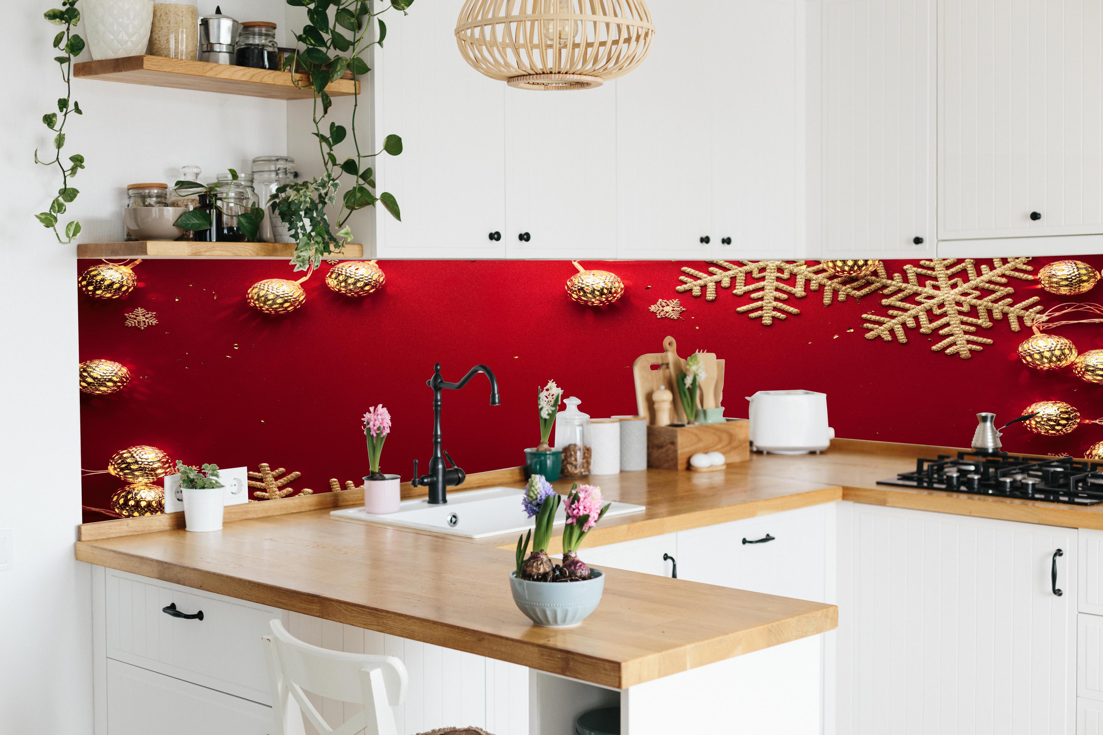 Küche - Weihnachtsdekoration auf rotem Hintergrund hinter weißen Hochglanz-Küchenregalen und schwarzem Wasserhahn