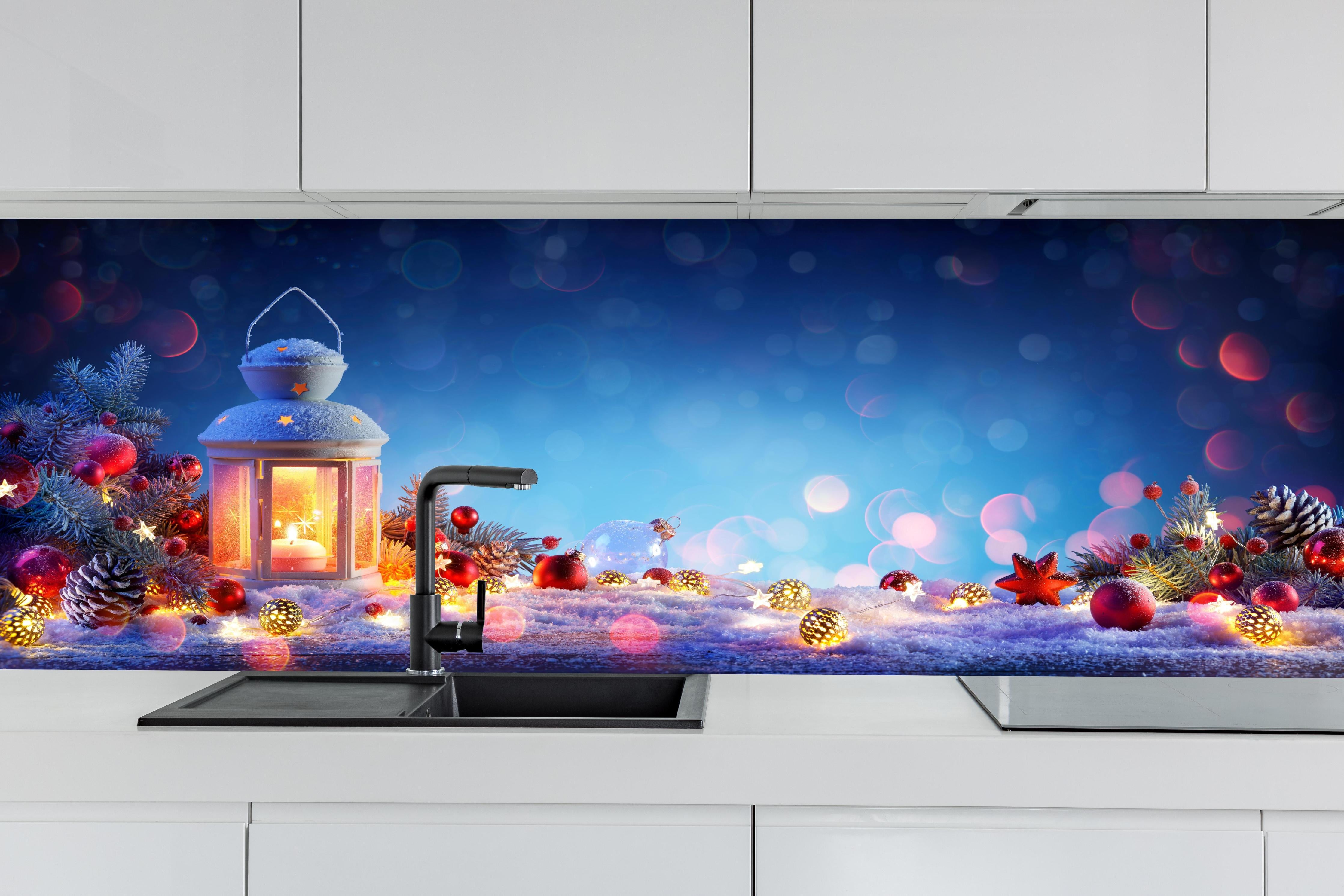 Küche - Weihnachtslaterne auf verschneiten Tisch hinter weißen Hochglanz-Küchenregalen und schwarzem Wasserhahn