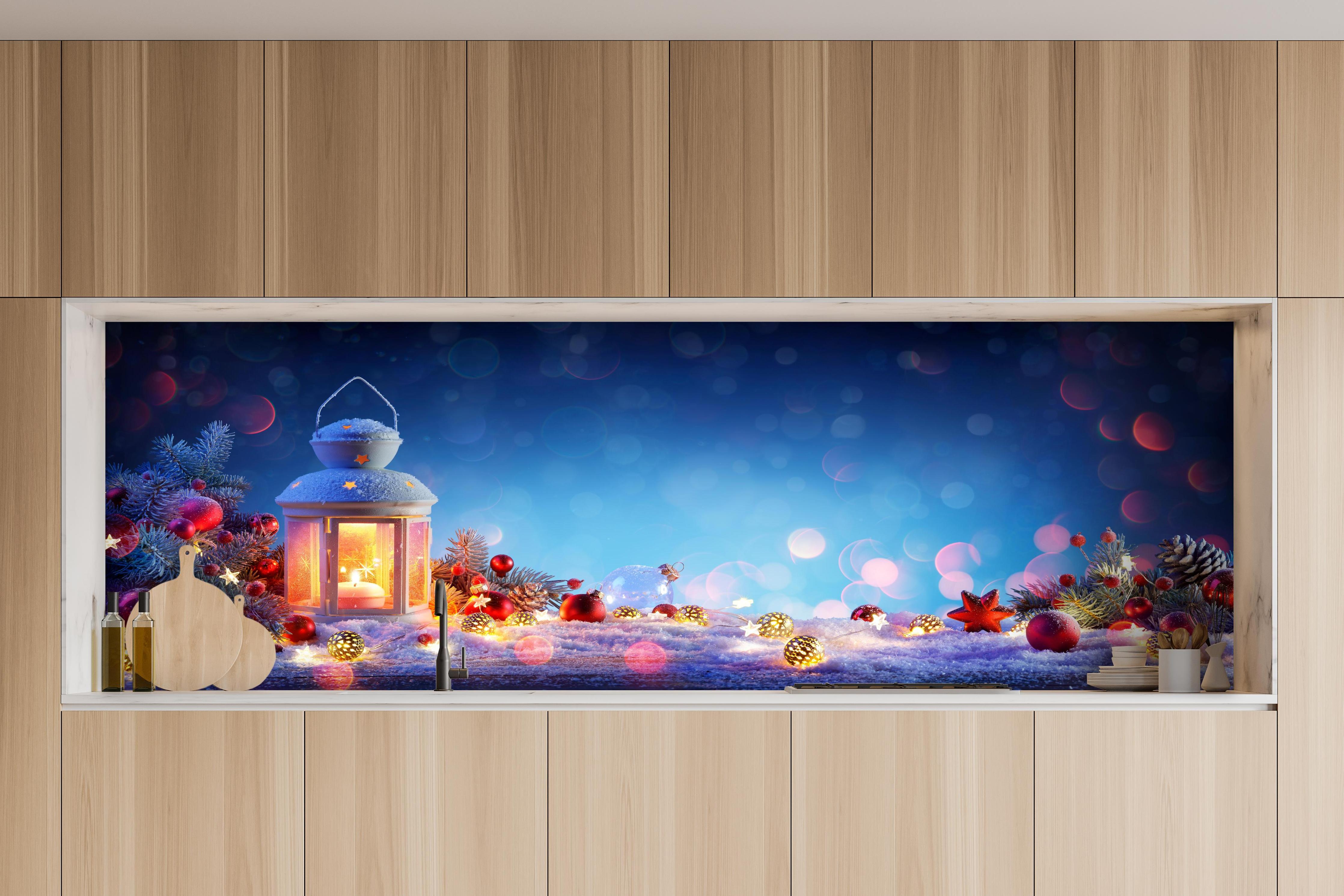 Küche - Weihnachtslaterne auf verschneiten Tisch hinter weißen Hochglanz-Küchenregalen und schwarzem Wasserhahn