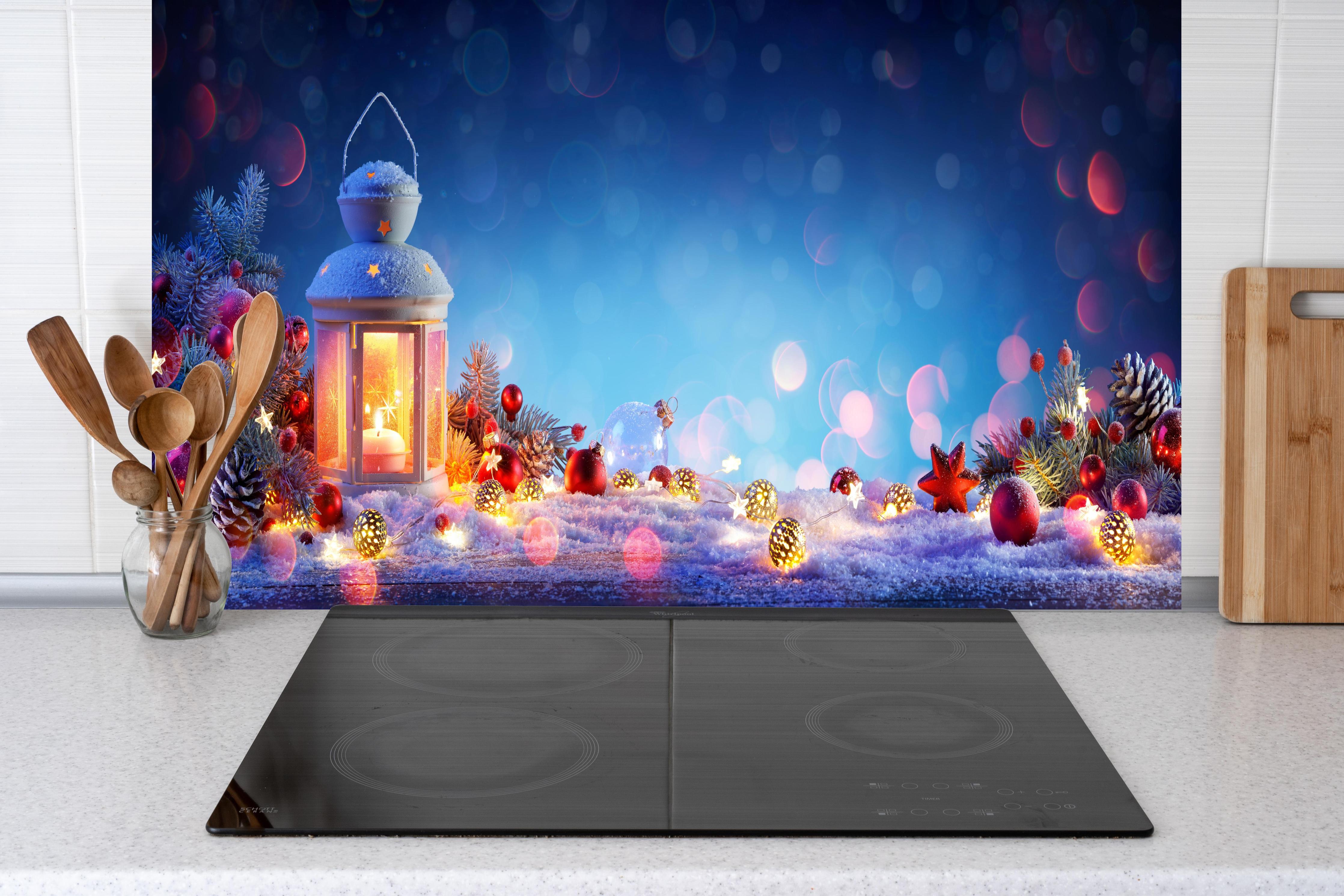 Küche - Weihnachtslaterne auf verschneiten Tisch hinter weißen Hochglanz-Küchenregalen und schwarzem Wasserhahn