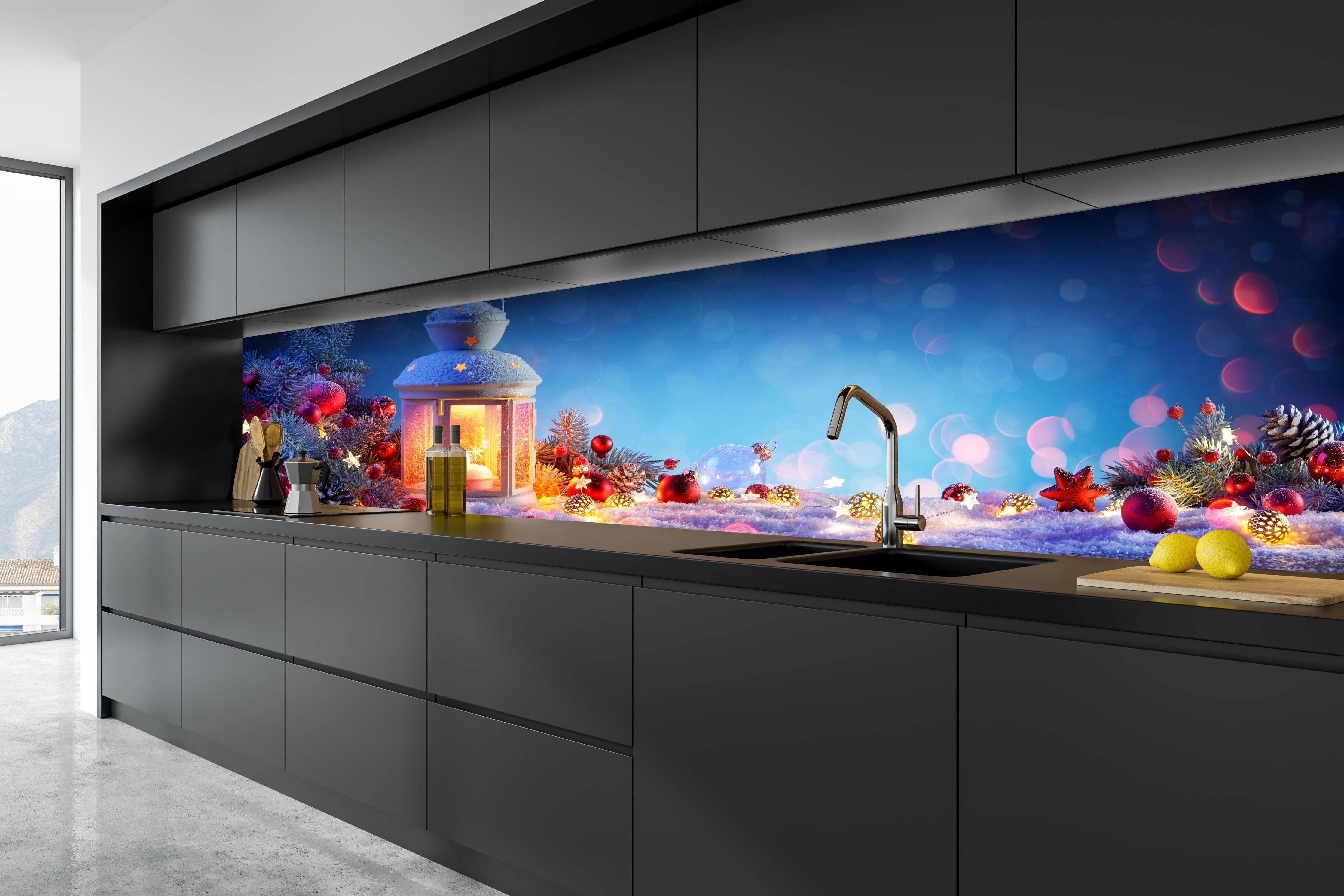 Küche - Weihnachtslaterne auf verschneiten Tisch hinter weißen Hochglanz-Küchenregalen und schwarzem Wasserhahn