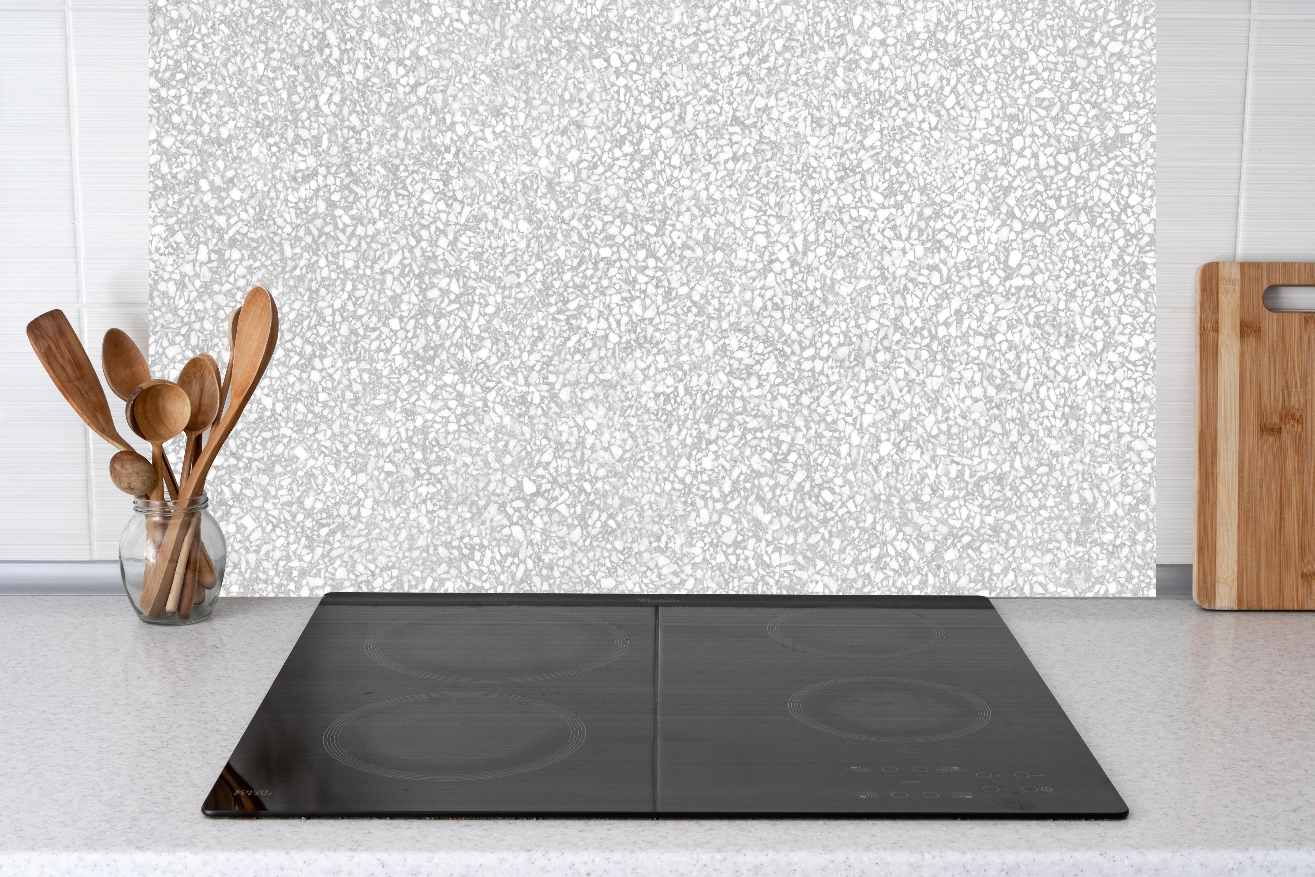 Küche - Weißer Terrazzostein hinter weißen Hochglanz-Küchenregalen und schwarzem Wasserhahn