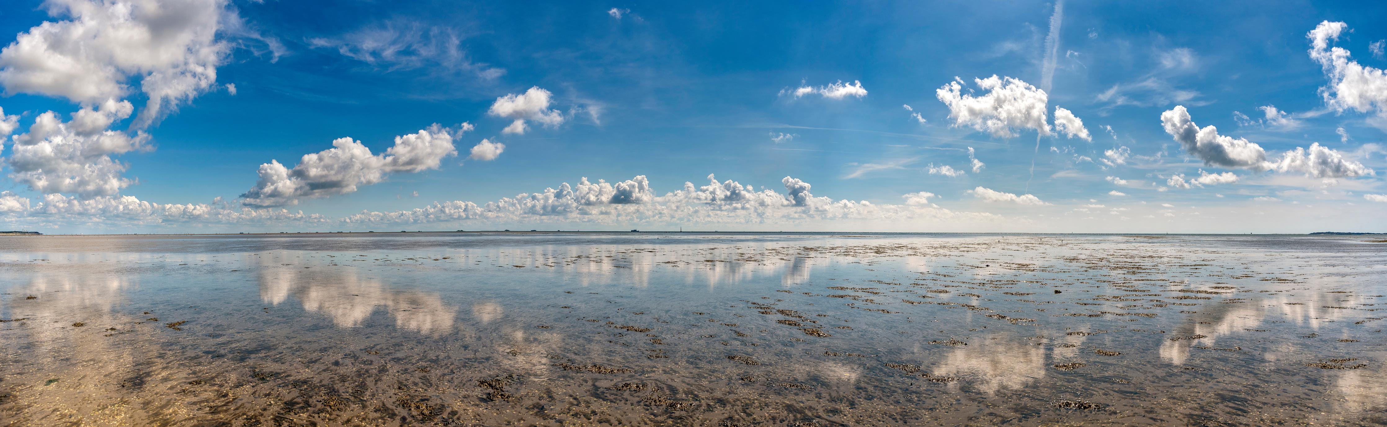 Küchenrückwand-Weitläufiger Himmel und spiegelnde Wasseroberfläche mit Wolkenreflexionen
