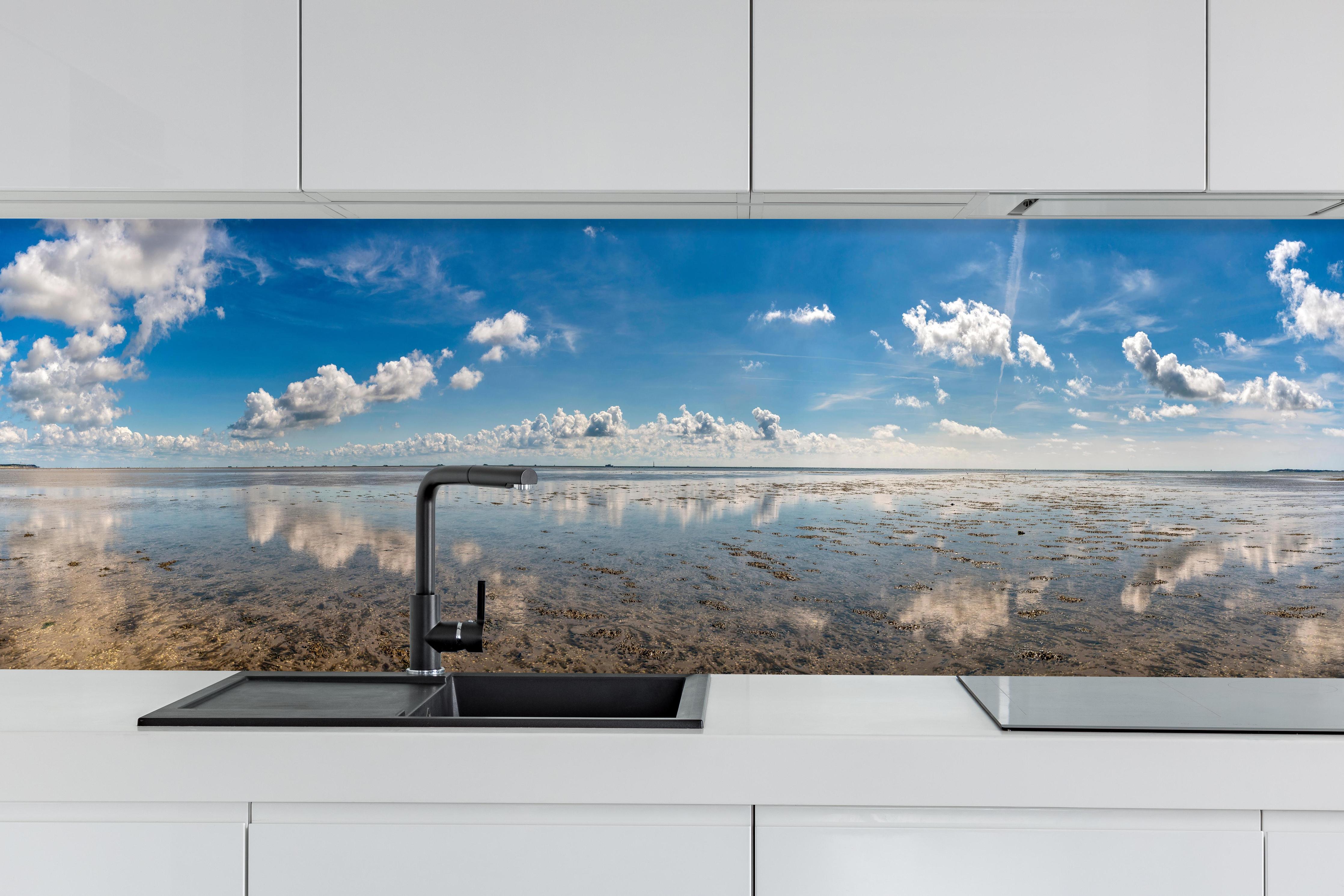 Küche - Weitläufiger Himmel und spiegelnde Wasseroberfläche mit Wolkenreflexionen hinter weißen Hochglanz-Küchenregalen und schwarzem Wasserhahn