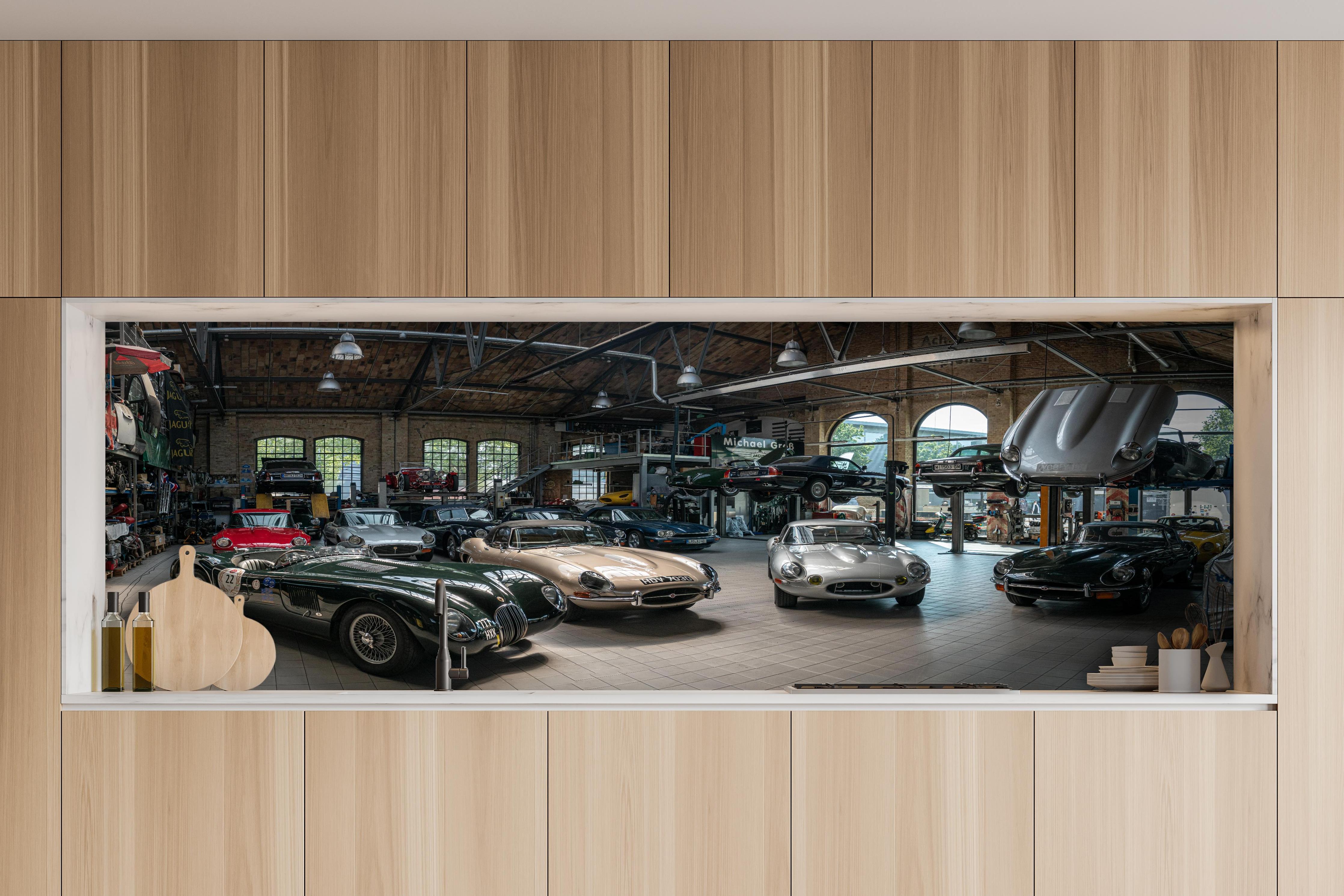 Küche - Werkstatt für die Reparatur und Wartung englischer Retro-Klassiker hinter weißen Hochglanz-Küchenregalen und schwarzem Wasserhahn