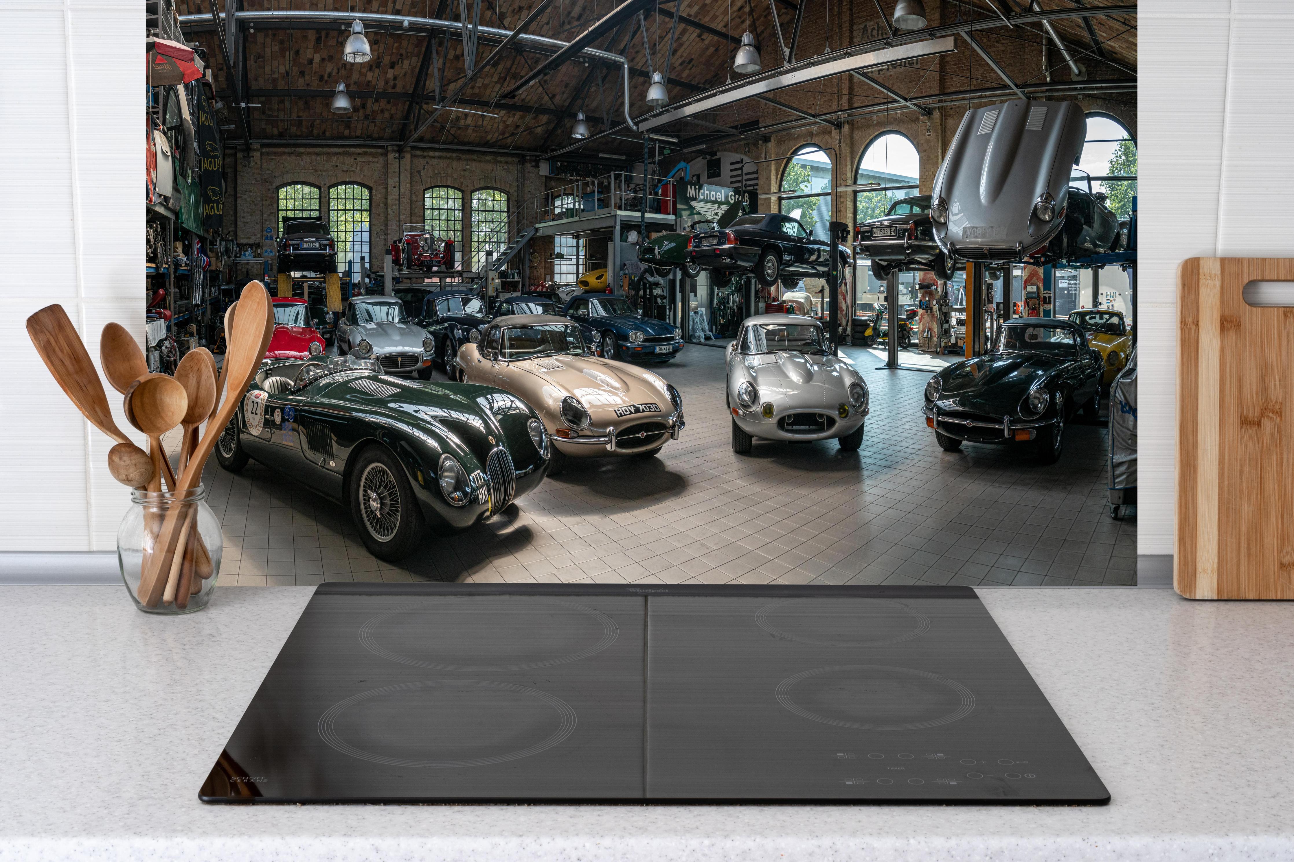 Küche - Werkstatt für die Reparatur und Wartung englischer Retro-Klassiker hinter weißen Hochglanz-Küchenregalen und schwarzem Wasserhahn