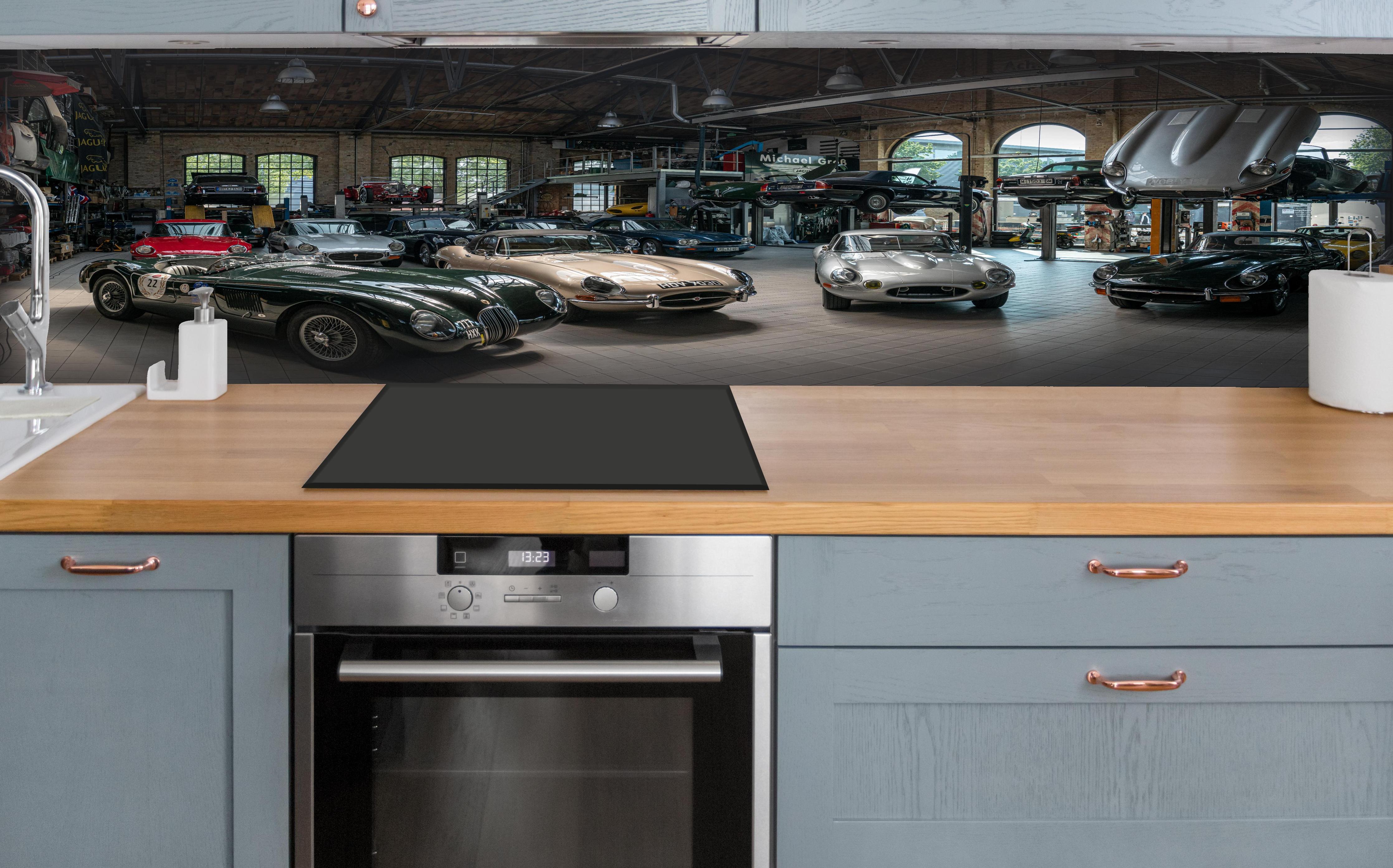 Küche - Werkstatt für die Reparatur und Wartung englischer Retro-Klassiker hinter weißen Hochglanz-Küchenregalen und schwarzem Wasserhahn