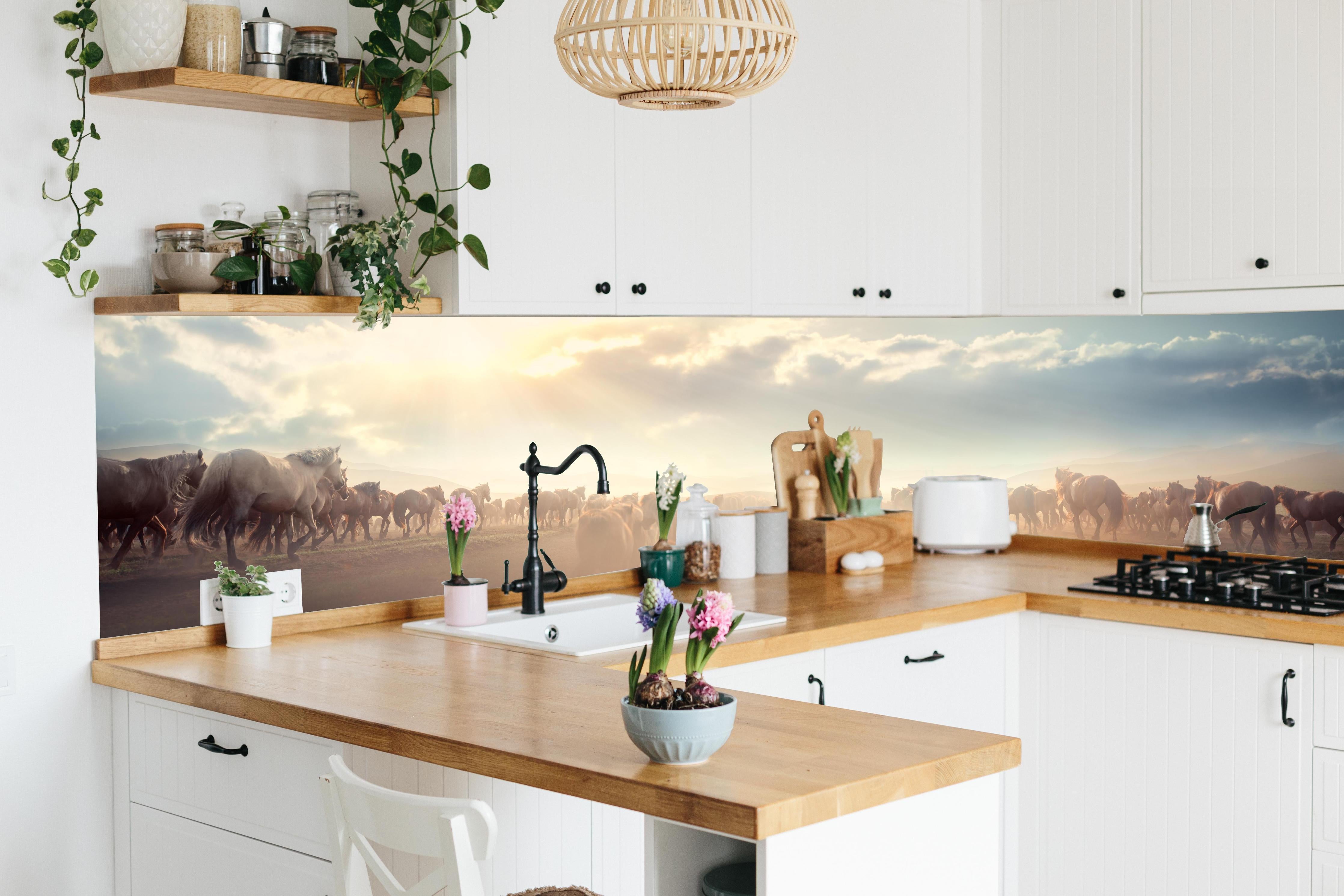 Küche - Wildpferde-Herde begegnet Sonnenuntergangspanorama hinter weißen Hochglanz-Küchenregalen und schwarzem Wasserhahn