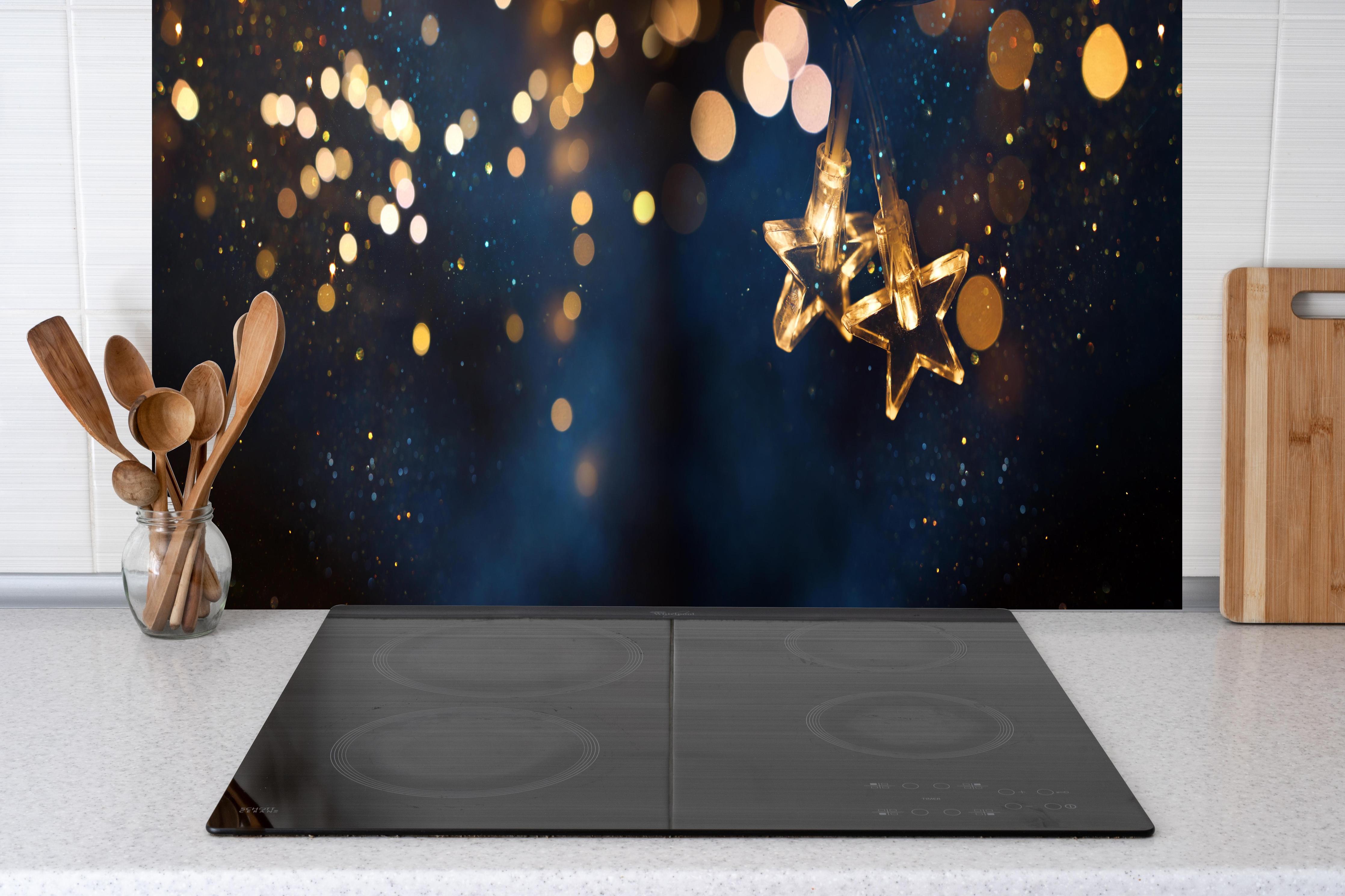 Küche - Winterliche Dekoration - Lichterkette hinter weißen Hochglanz-Küchenregalen und schwarzem Wasserhahn