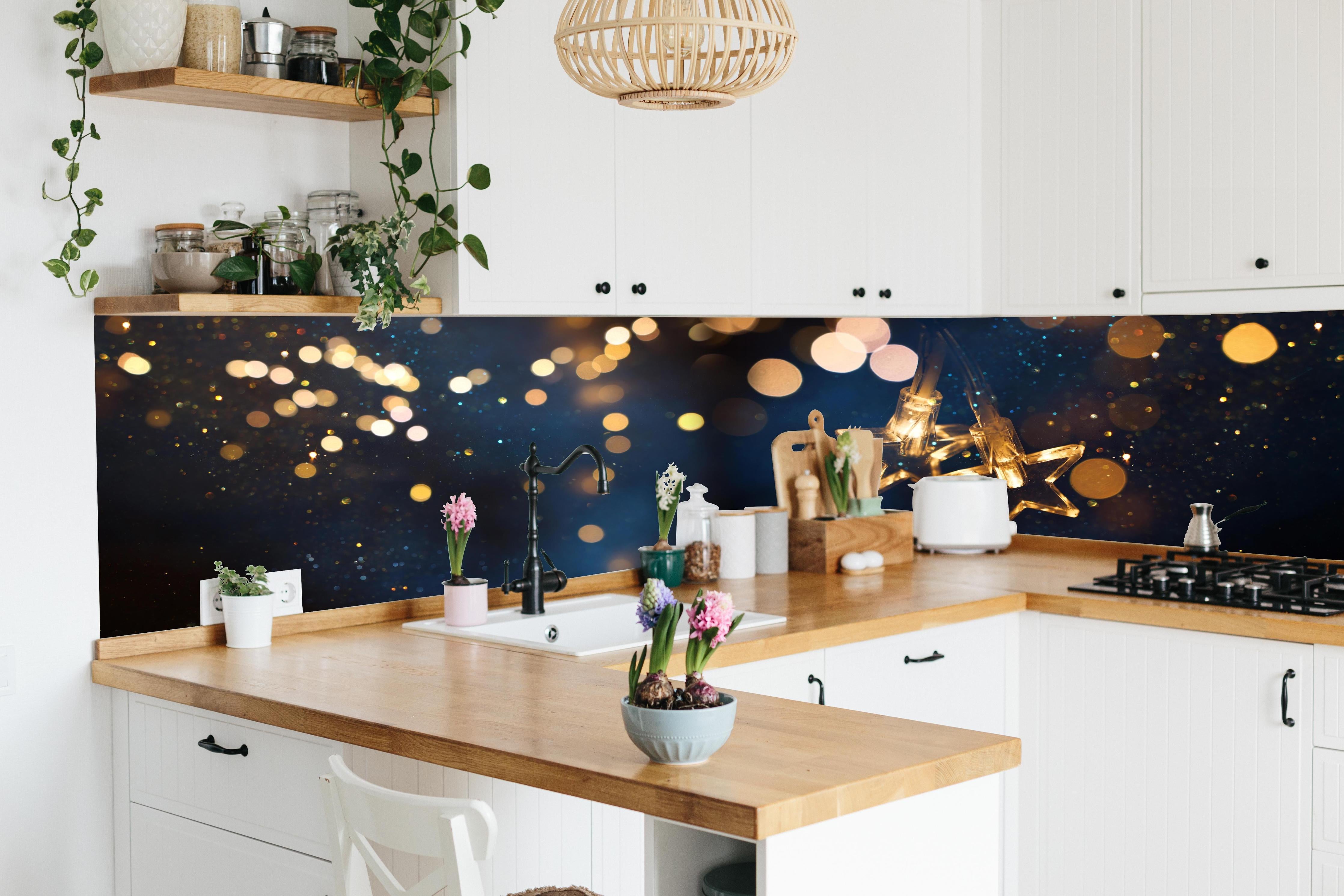 Küche - Winterliche Dekoration - Lichterkette hinter weißen Hochglanz-Küchenregalen und schwarzem Wasserhahn