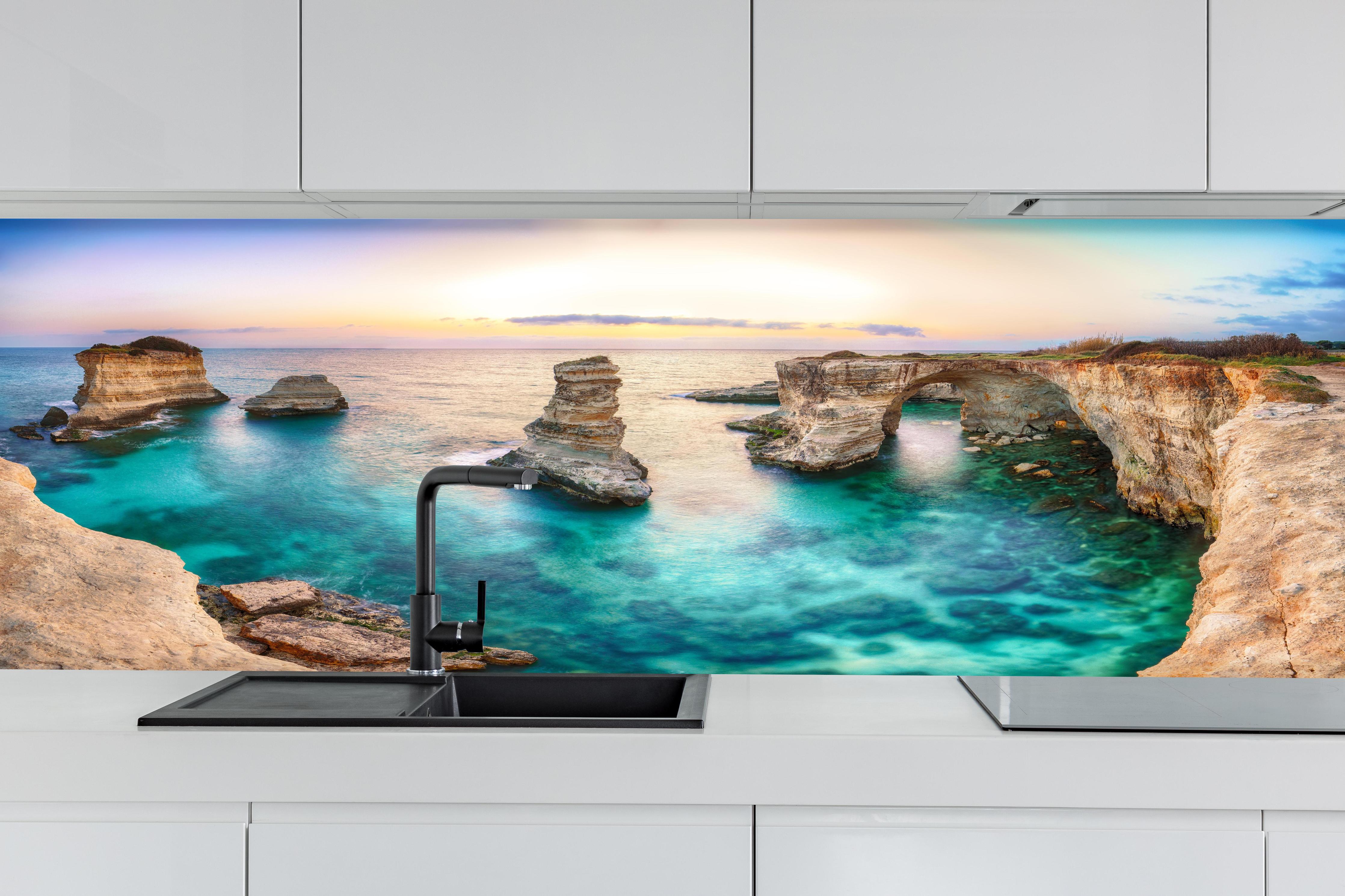 Küche - Wunderschönes Küstenpanorama mit klarem, türkisfarbenem Wasser und Felsen hinter weißen Hochglanz-Küchenregalen und schwarzem Wasserhahn