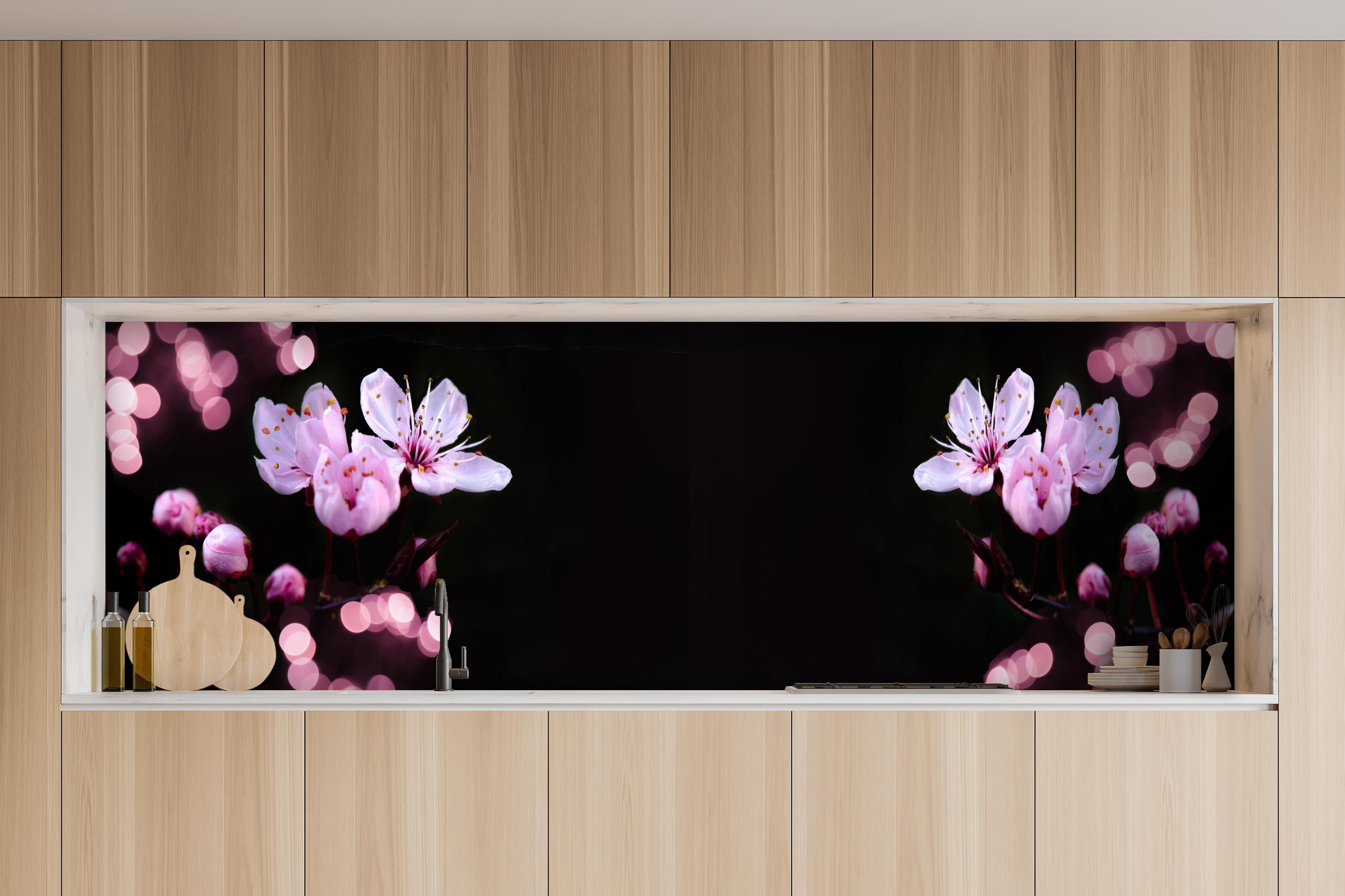 Küche - Zarte Rosa Kirschblüten beleuchtet in Dunkelheit hinter weißen Hochglanz-Küchenregalen und schwarzem Wasserhahn