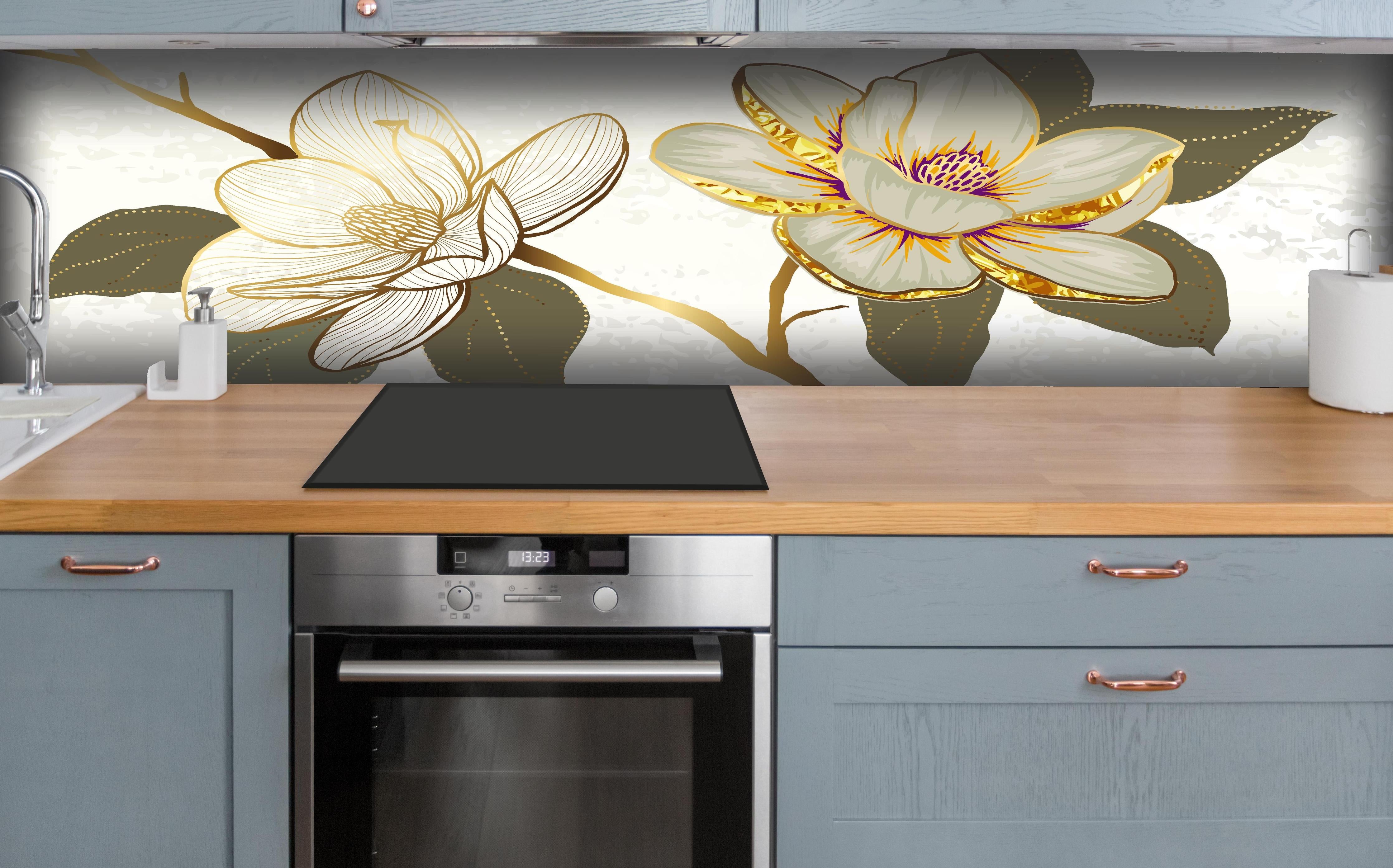 Küche - Zeichnung Magnolienblüten Weiß Gold Akzente hinter weißen Hochglanz-Küchenregalen und schwarzem Wasserhahn