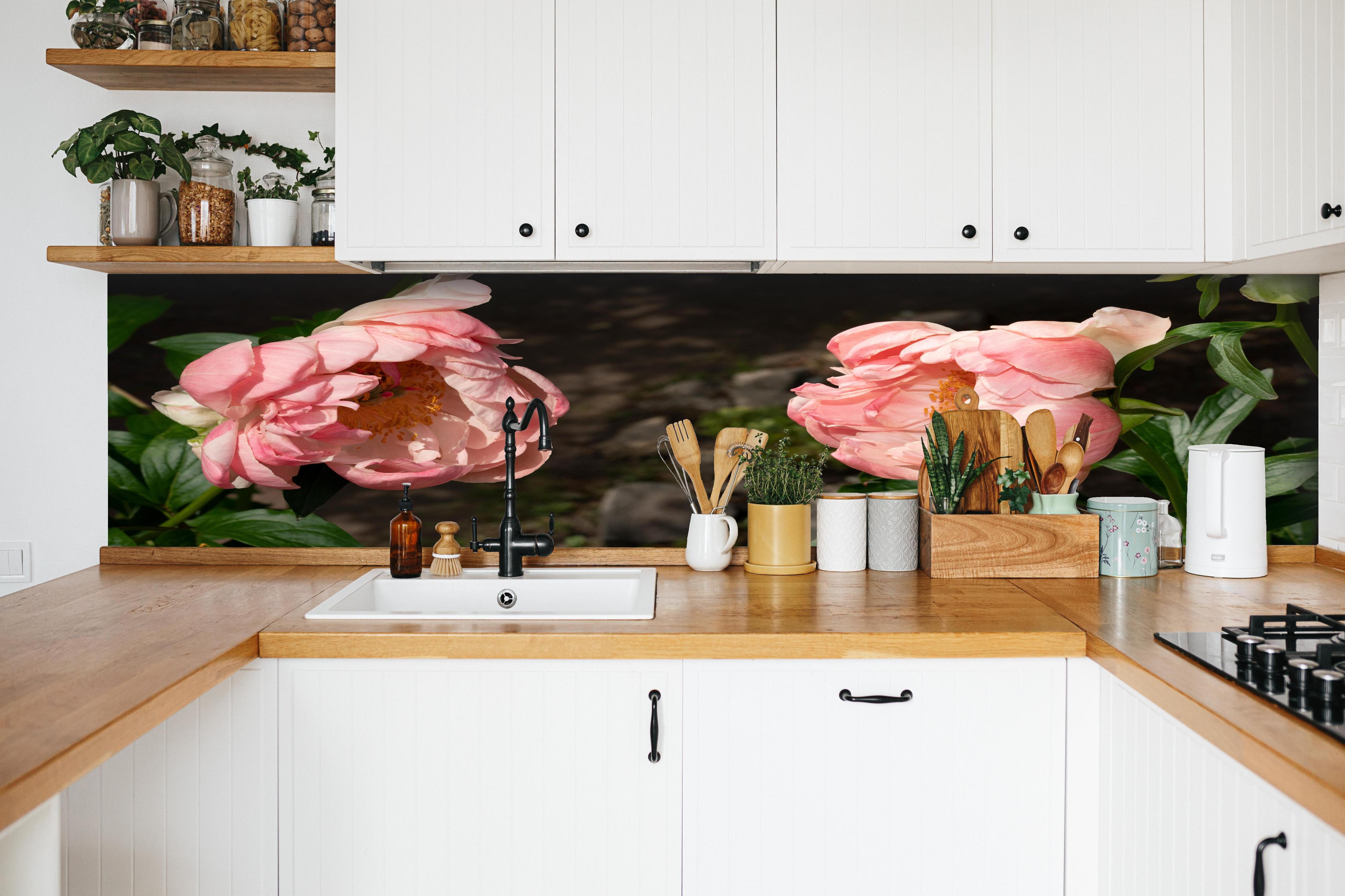 Küche - Zwei rosa Pfingstrosen in einem alten Garten. hinter weißen Hochglanz-Küchenregalen und schwarzem Wasserhahn