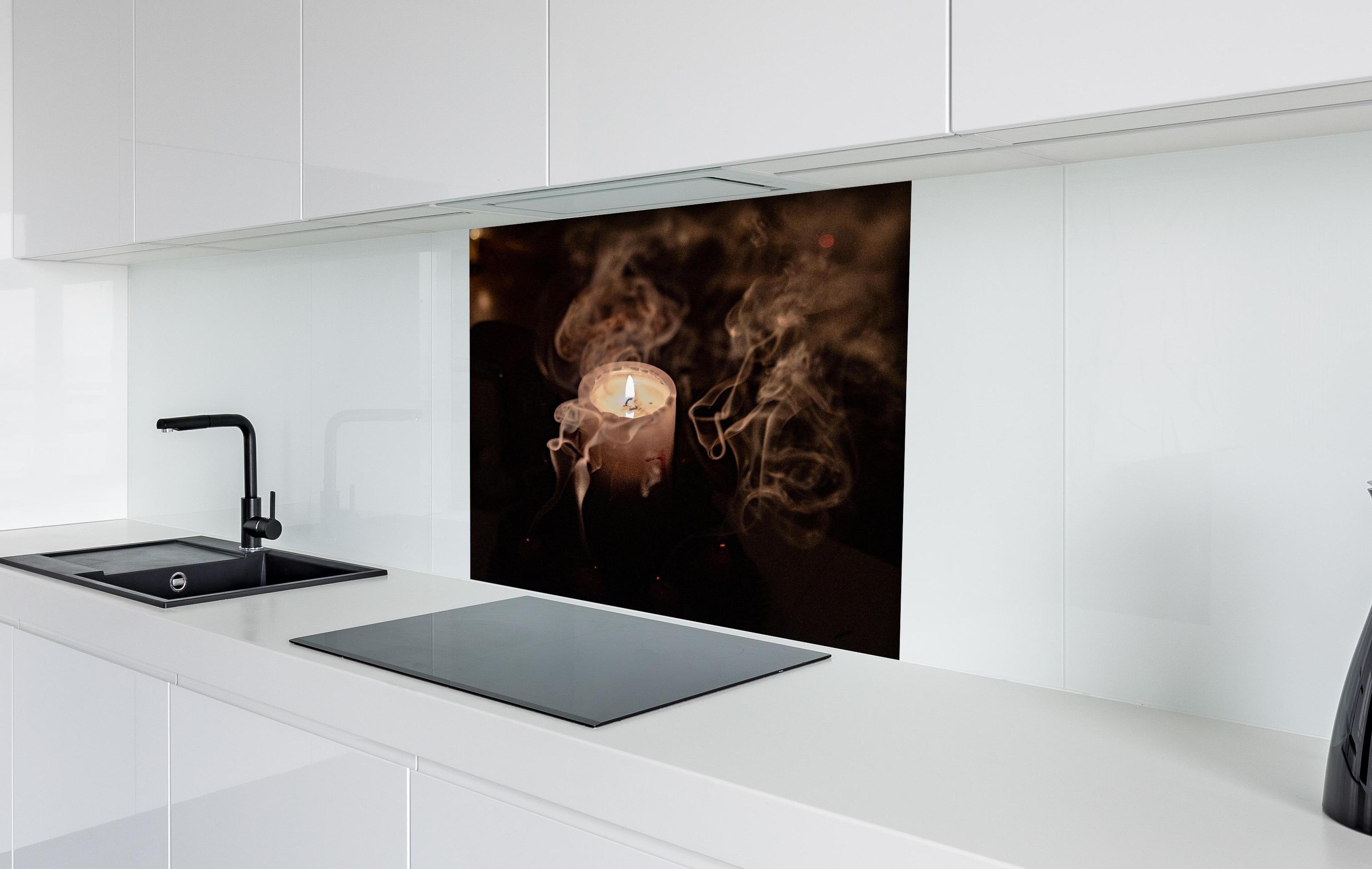Spritzschutz - Mystischer Kerzenrauch bei brennender Kerze hinter einem Cerankochfeld zwischen Holz-Kochutensilien