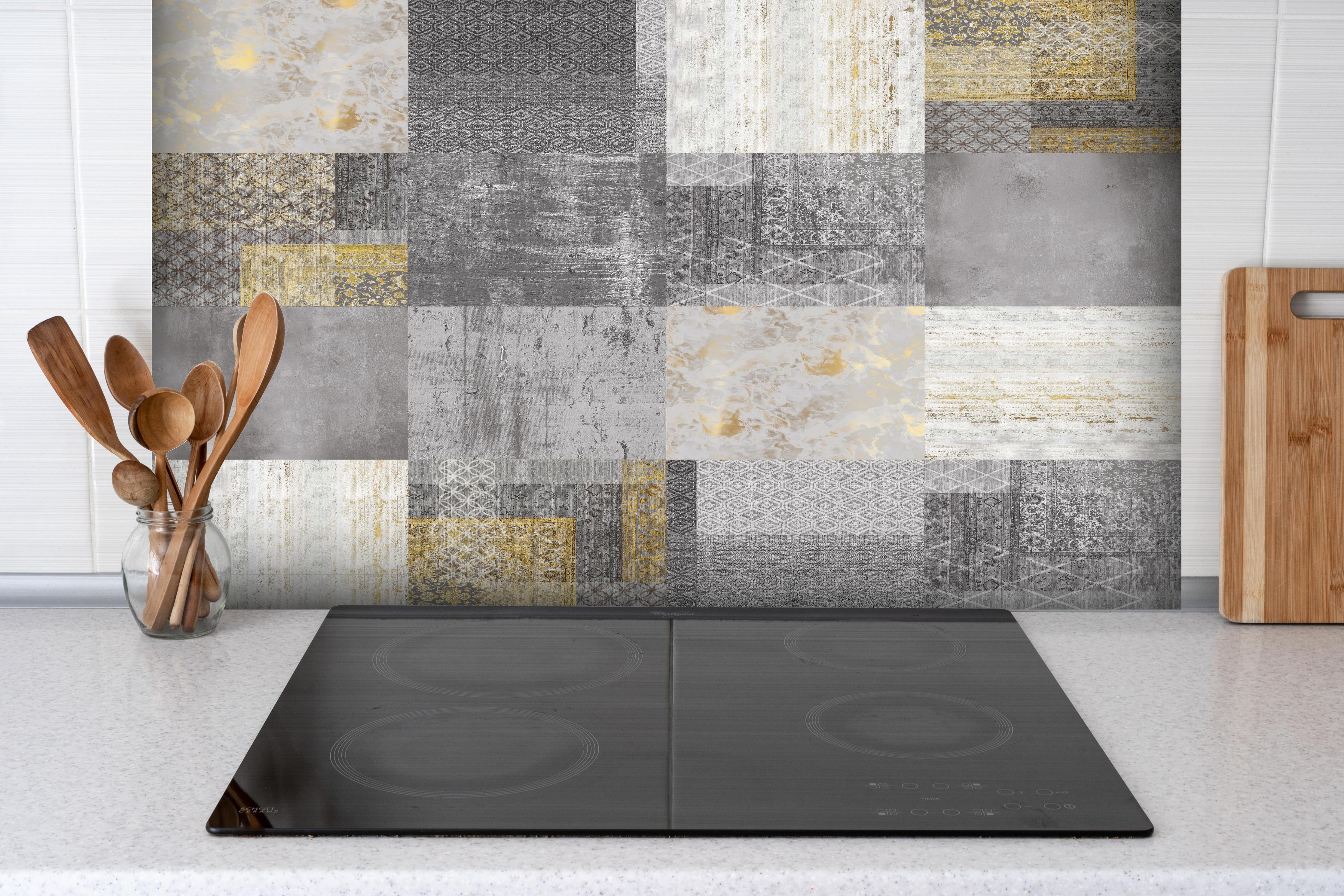 Spritzschutz - gräulich gelbes Patchwork hinter einem Cerankochfeld zwischen Holz-Kochutensilien