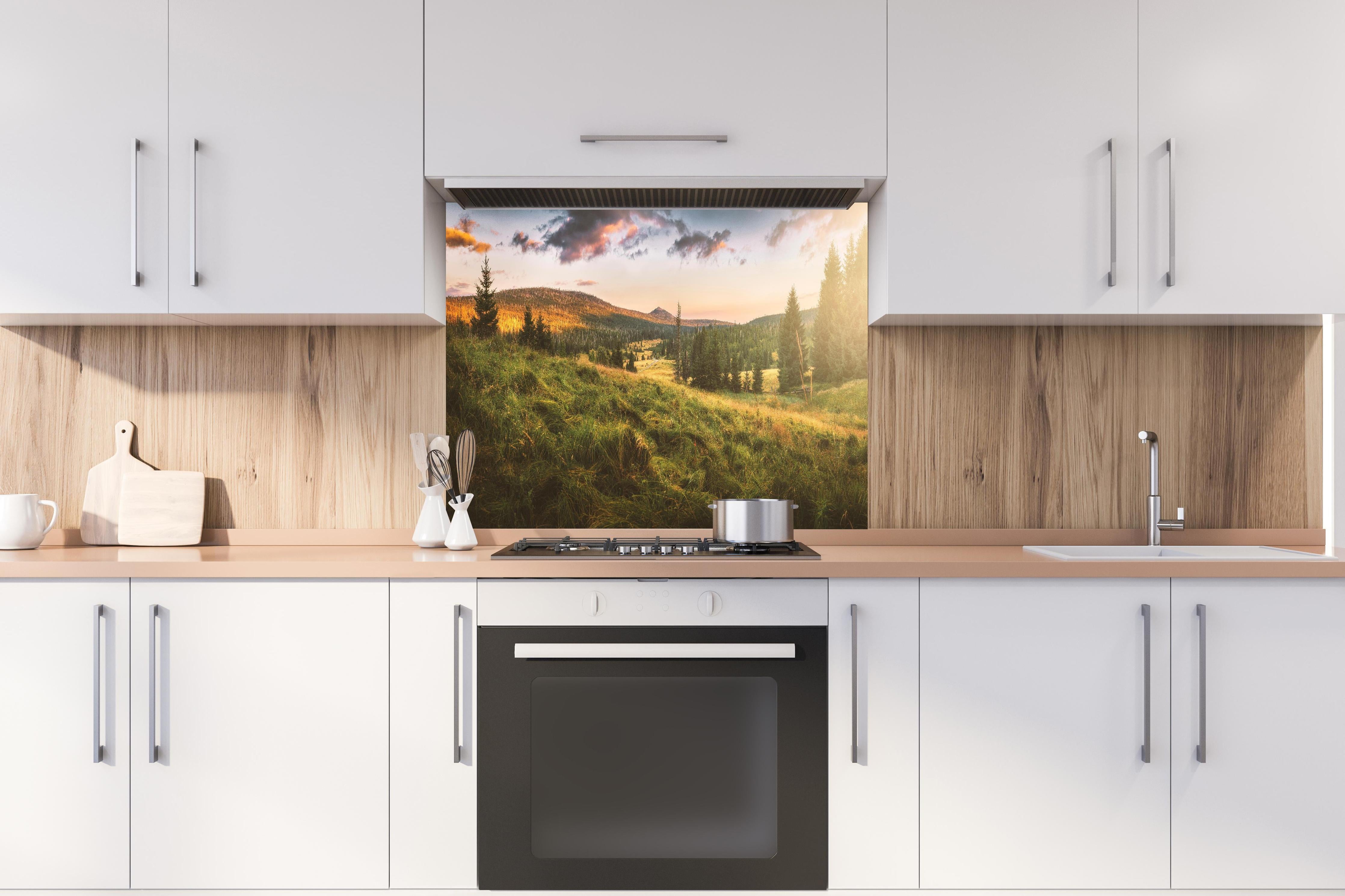 Spritzschutz - Abendlicher Berg Luzný - Tschechien hinter einem Cerankochfeld zwischen Holz-Kochutensilien