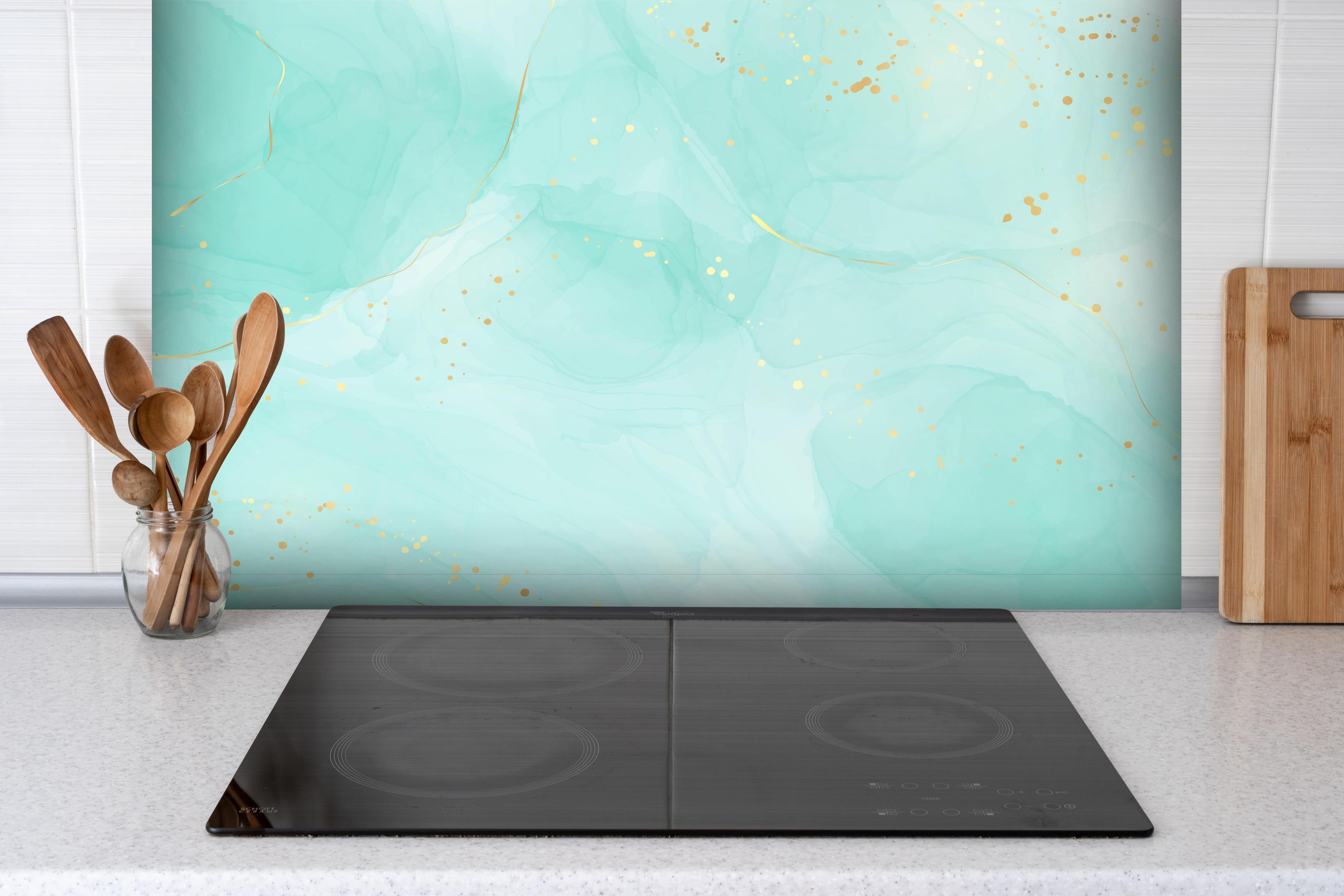 Spritzschutz - Abstrakte Aquarell-Kunst in Türkis mit Goldakzenten hinter einem Cerankochfeld zwischen Holz-Kochutensilien