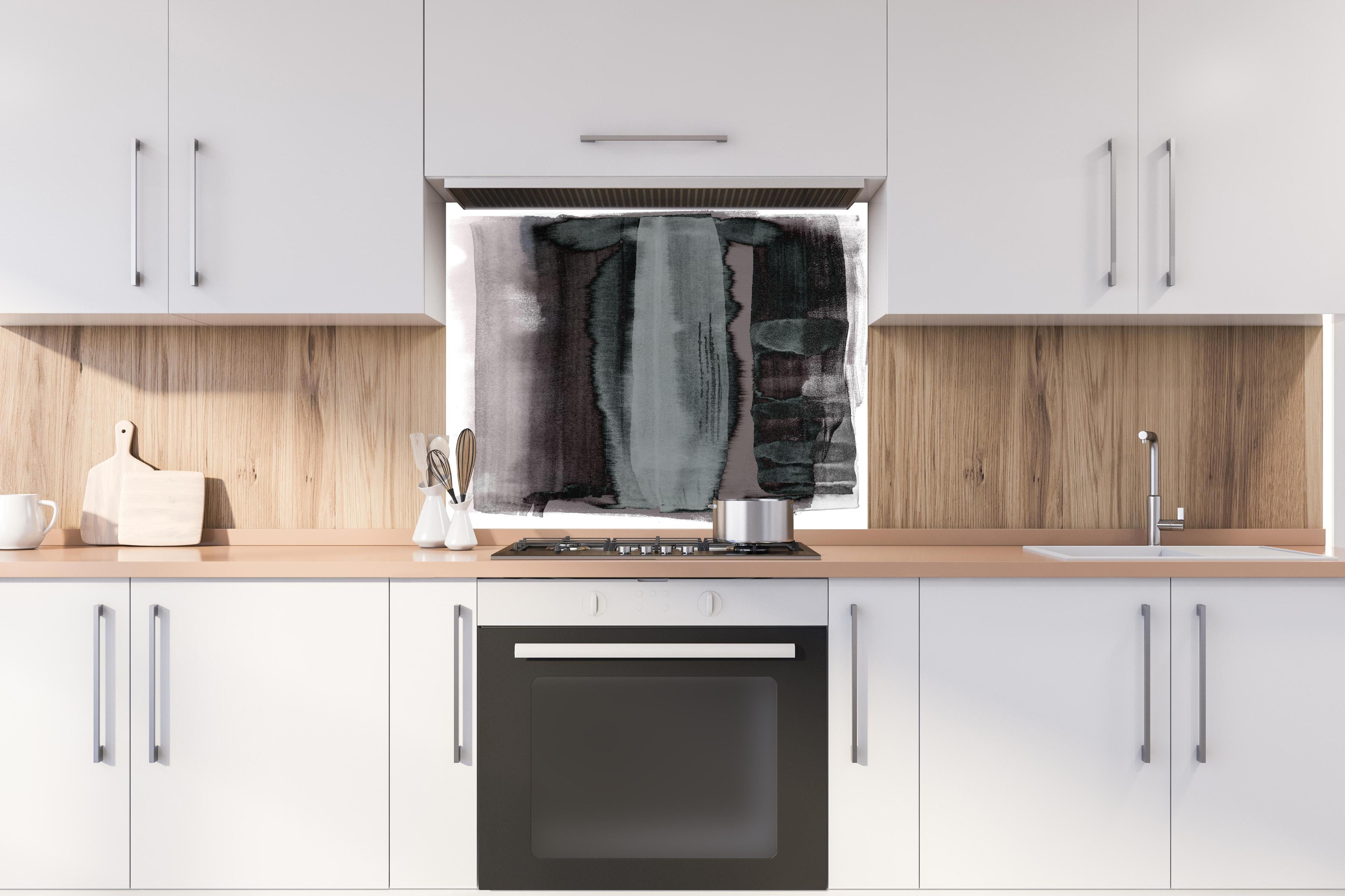 Spritzschutz - Abstrakte Aquarellmalerei in Grün-Schwarz hinter einem Cerankochfeld zwischen Holz-Kochutensilien