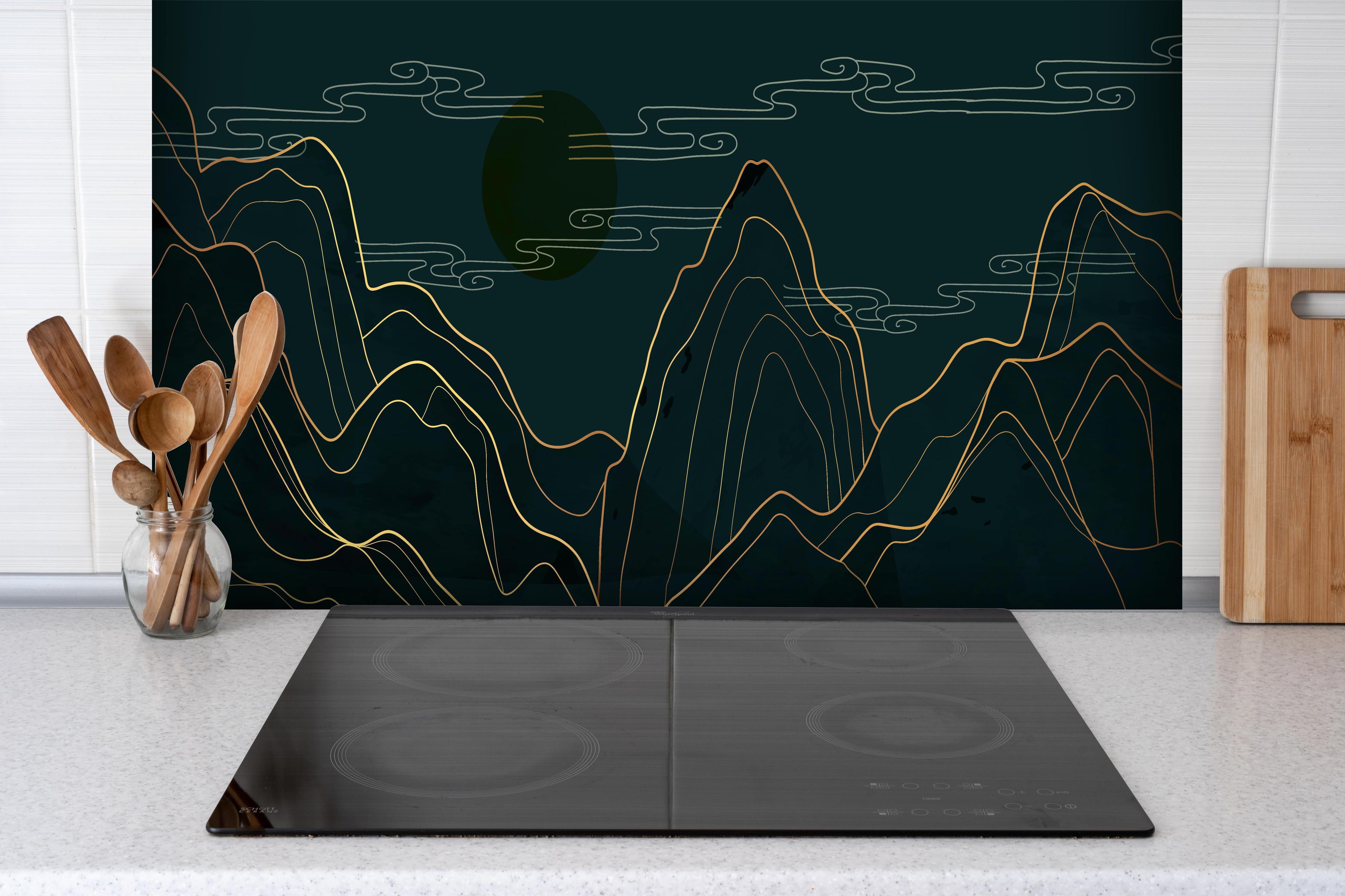 Spritzschutz - Abstrakte Bergkonturen in dunklen Tönen hinter einem Cerankochfeld zwischen Holz-Kochutensilien