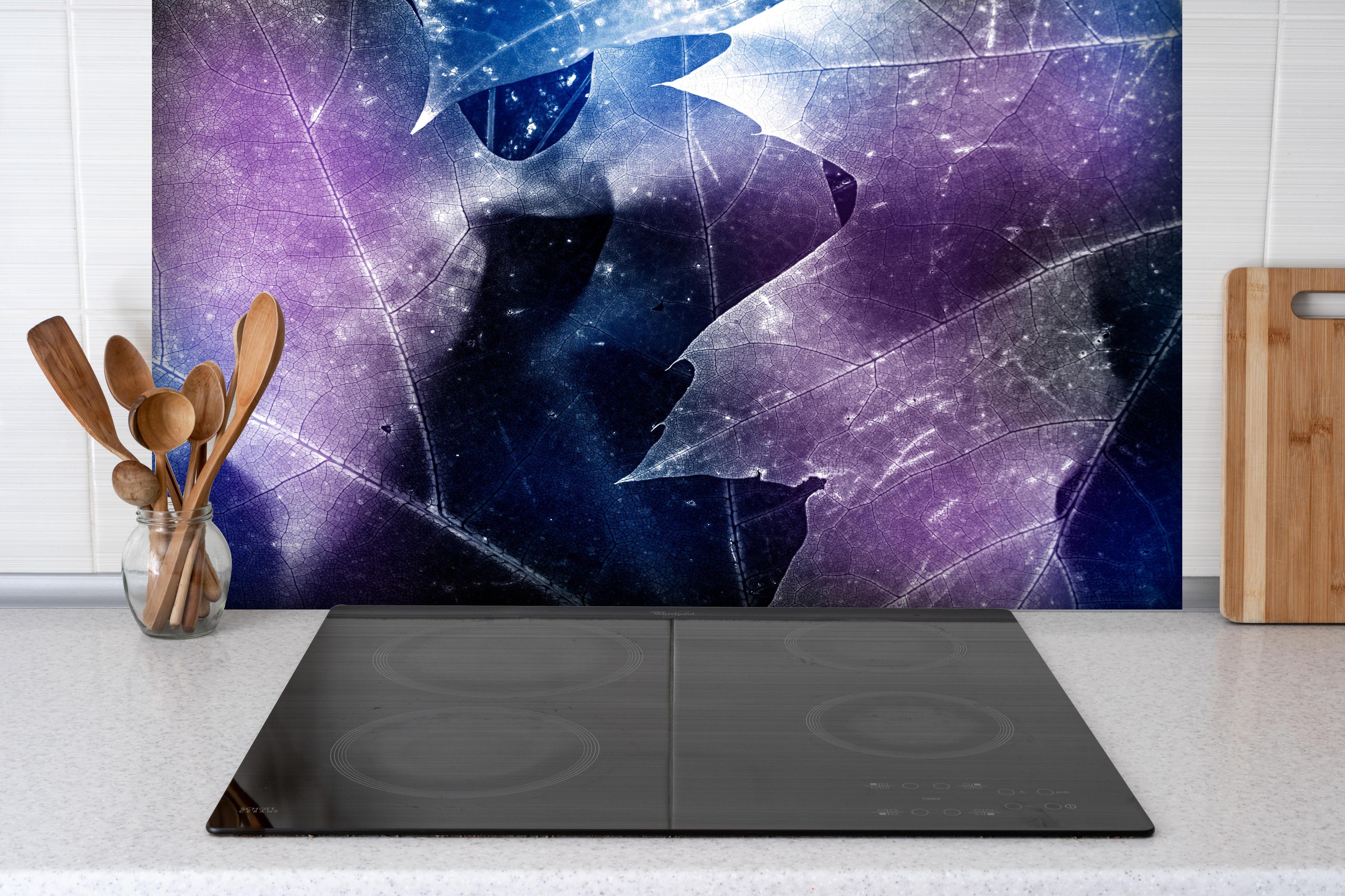 Spritzschutz - Abstrakte Blätterstruktur in Blau und Lila hinter einem Cerankochfeld zwischen Holz-Kochutensilien