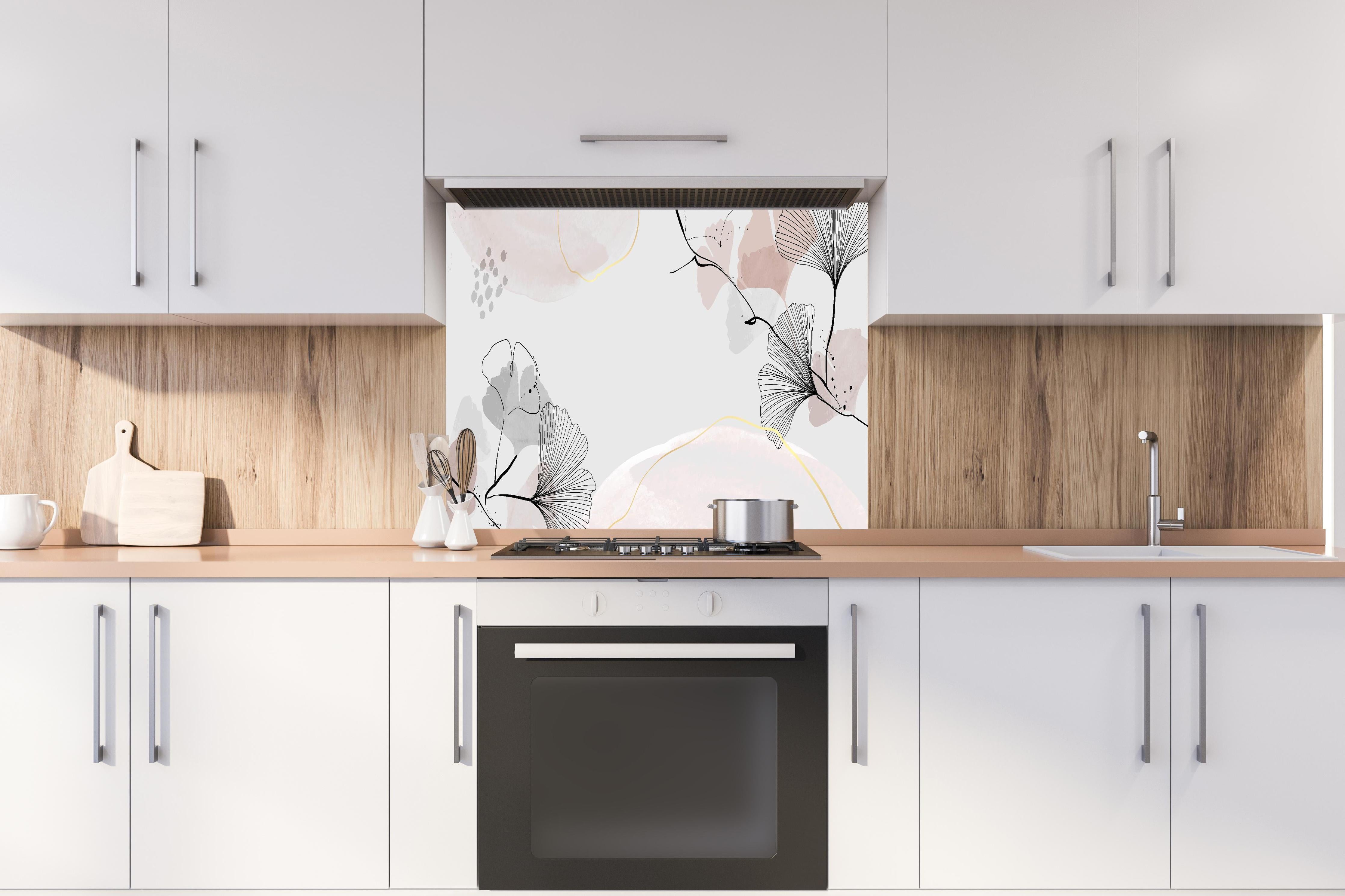 Spritzschutz - Abstrakte Ginkgo-Blätter in sanften Pastelltönen hinter einem Cerankochfeld zwischen Holz-Kochutensilien