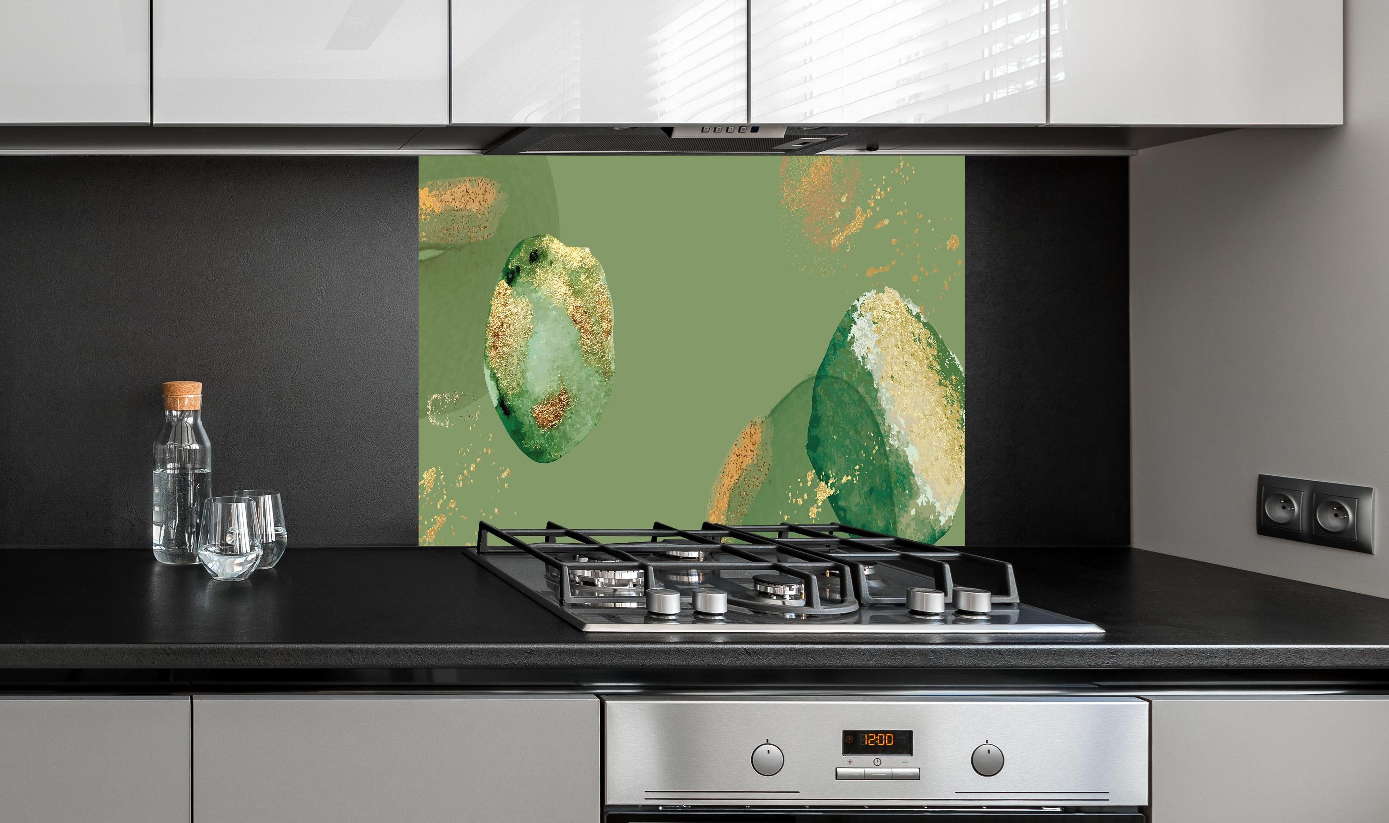 Spritzschutz - Abstrakte Kunst in Grün und Goldtönen hinter einem Cerankochfeld zwischen Holz-Kochutensilien