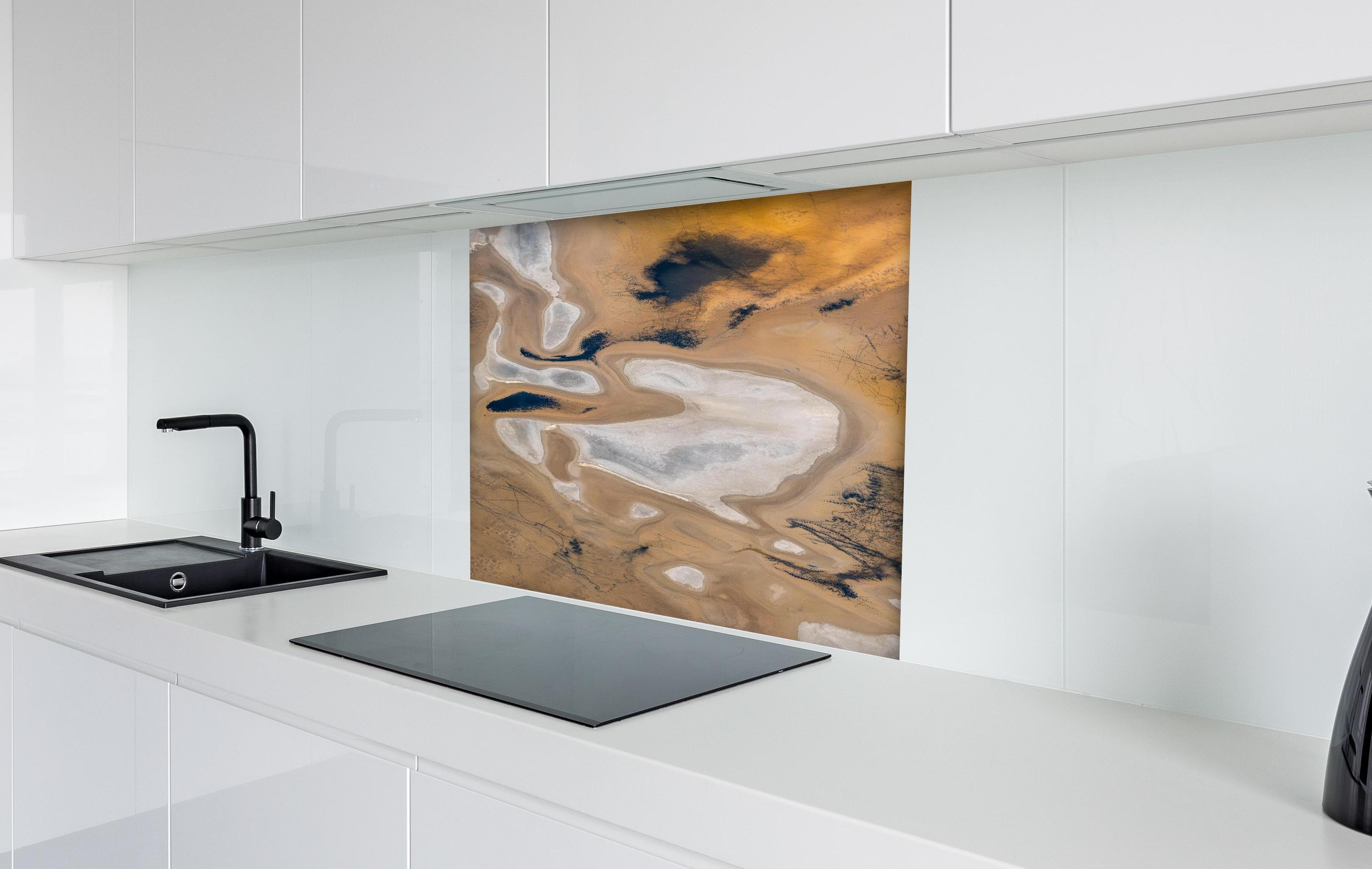 Spritzschutz - Abstrakte Landschaft in Beige-Tönen hinter einem Cerankochfeld zwischen Holz-Kochutensilien