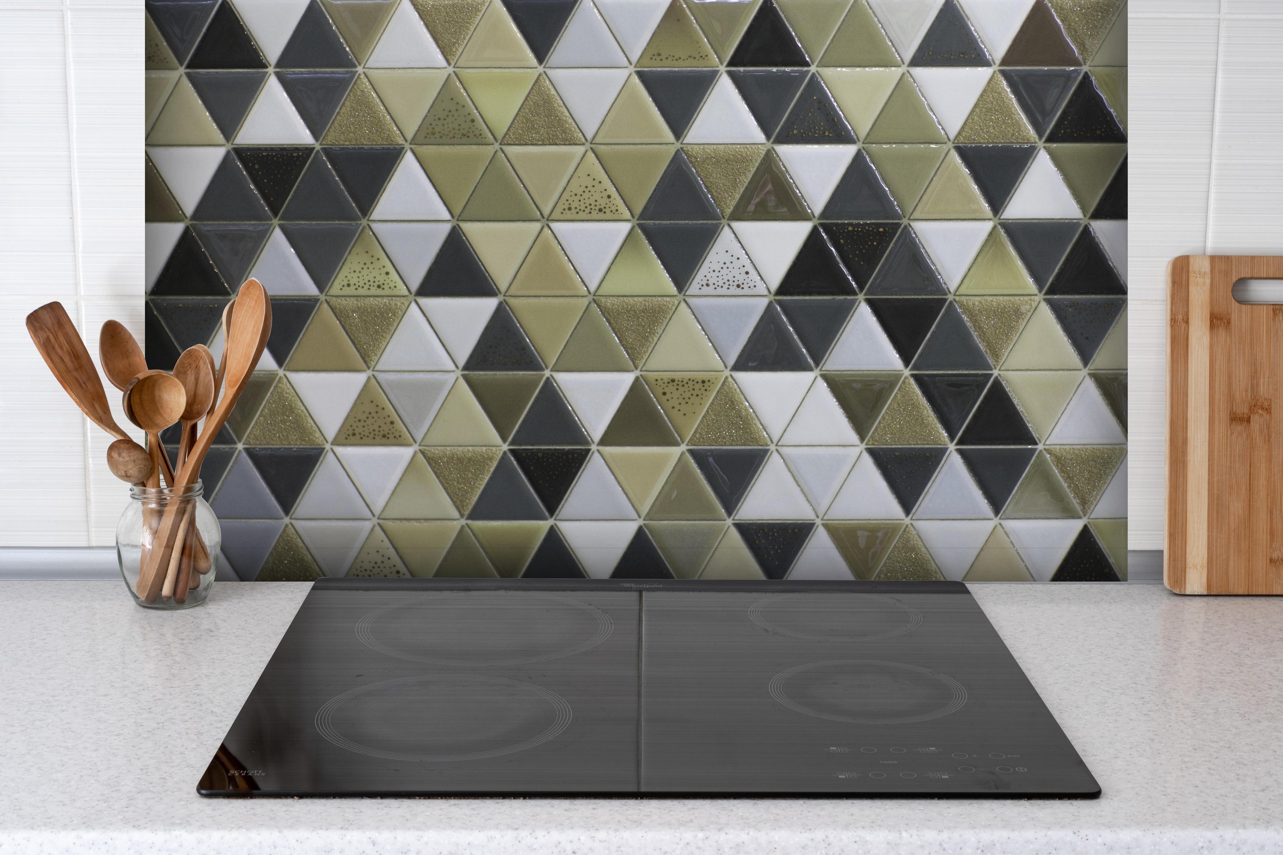 Spritzschutz - Abstrakte Mosaikfliese in Grautönen hinter einem Cerankochfeld zwischen Holz-Kochutensilien
