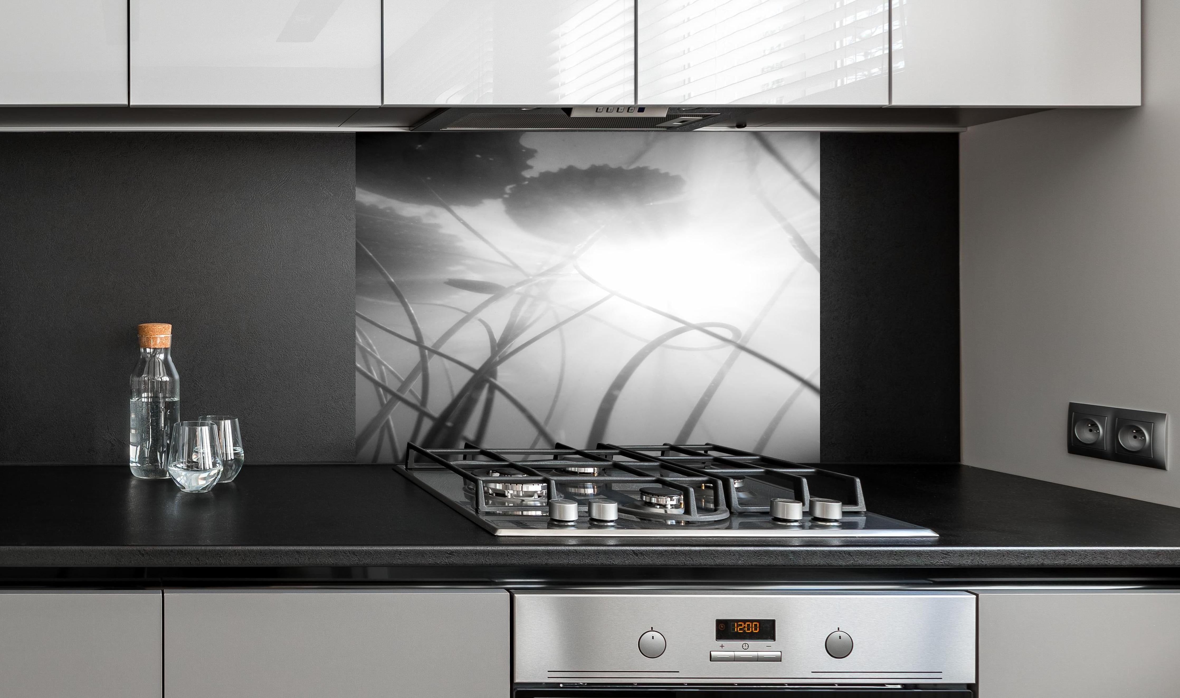 Spritzschutz - Abstrakte Seerose im Nebel Monochrom hinter einem Cerankochfeld zwischen Holz-Kochutensilien