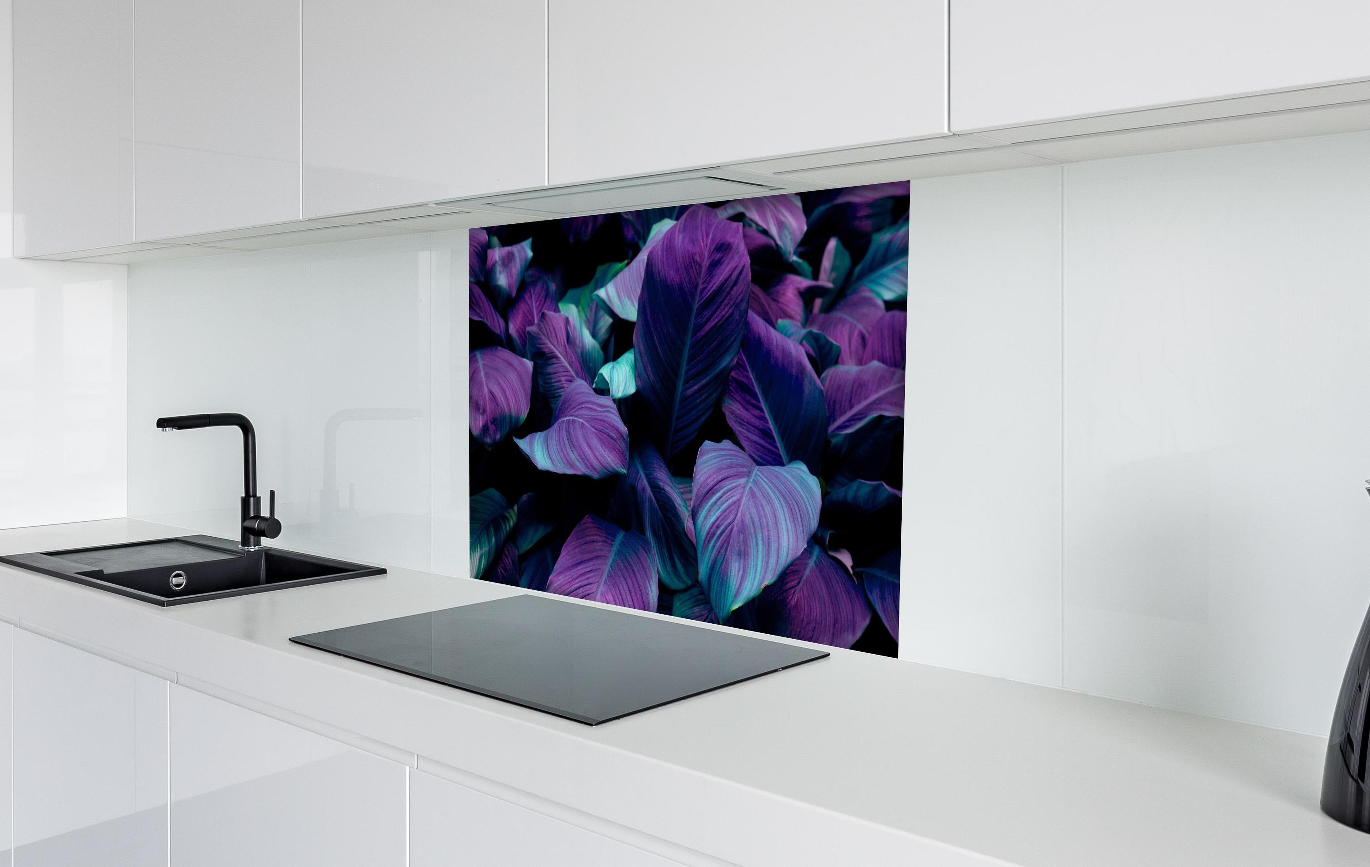 Spritzschutz - Abstrakte Tropenblätter in dunklen Farbtönen hinter einem Cerankochfeld zwischen Holz-Kochutensilien