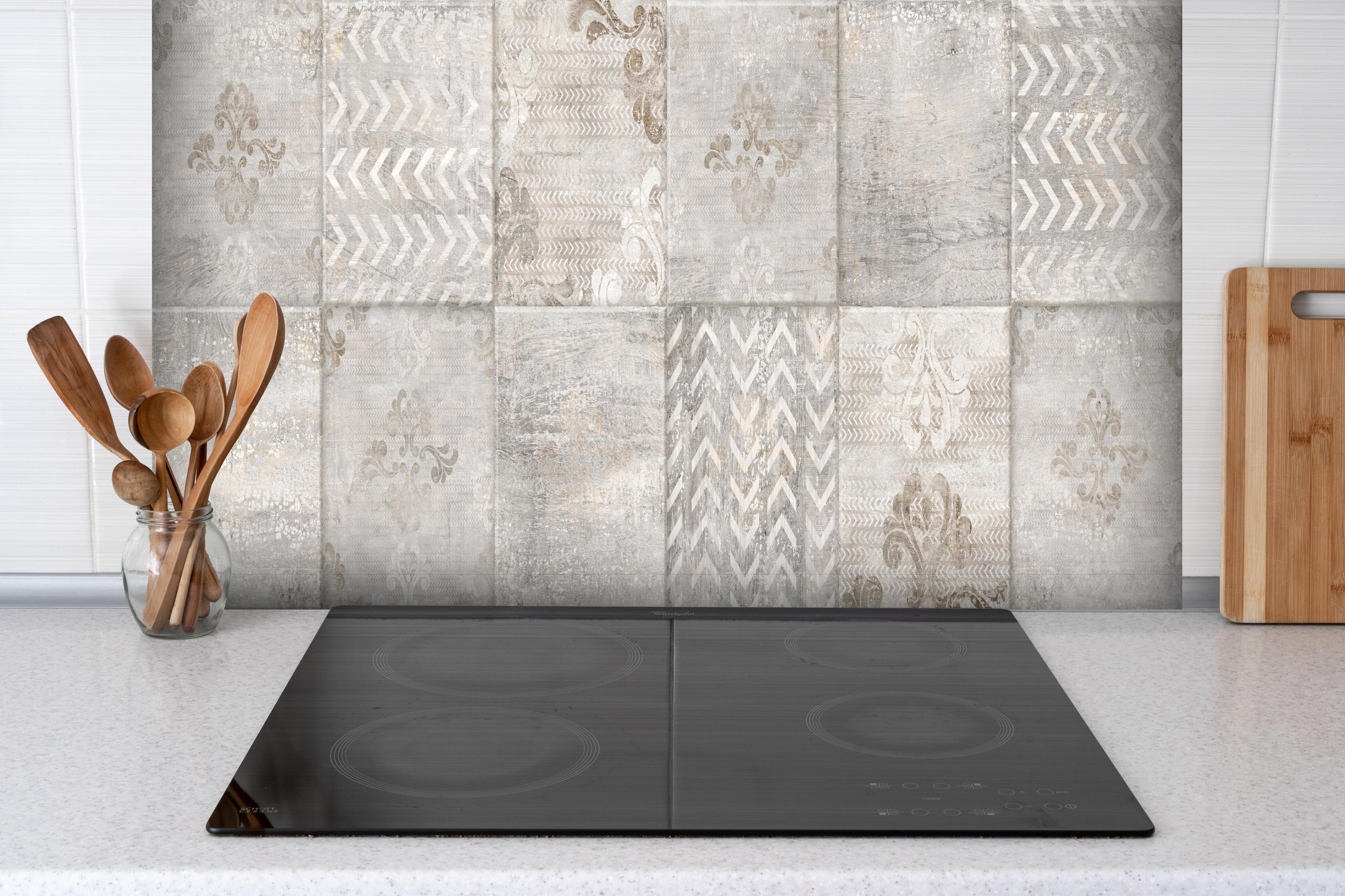 Spritzschutz - Abstrakter Mosaik Hintergrund hinter einem Cerankochfeld zwischen Holz-Kochutensilien