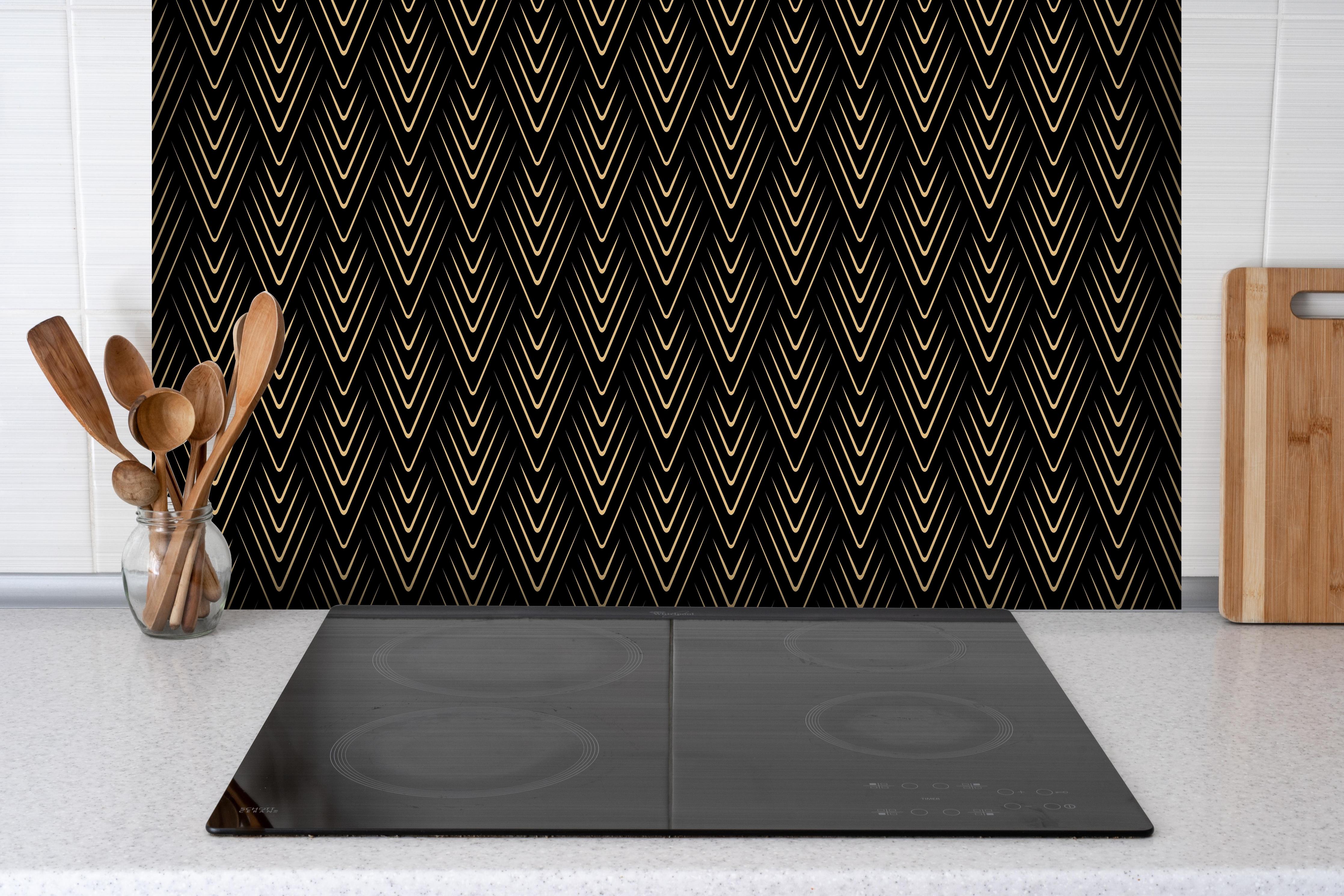 Spritzschutz - Abstraktes Designmuster in Schwarz hinter einem Cerankochfeld zwischen Holz-Kochutensilien