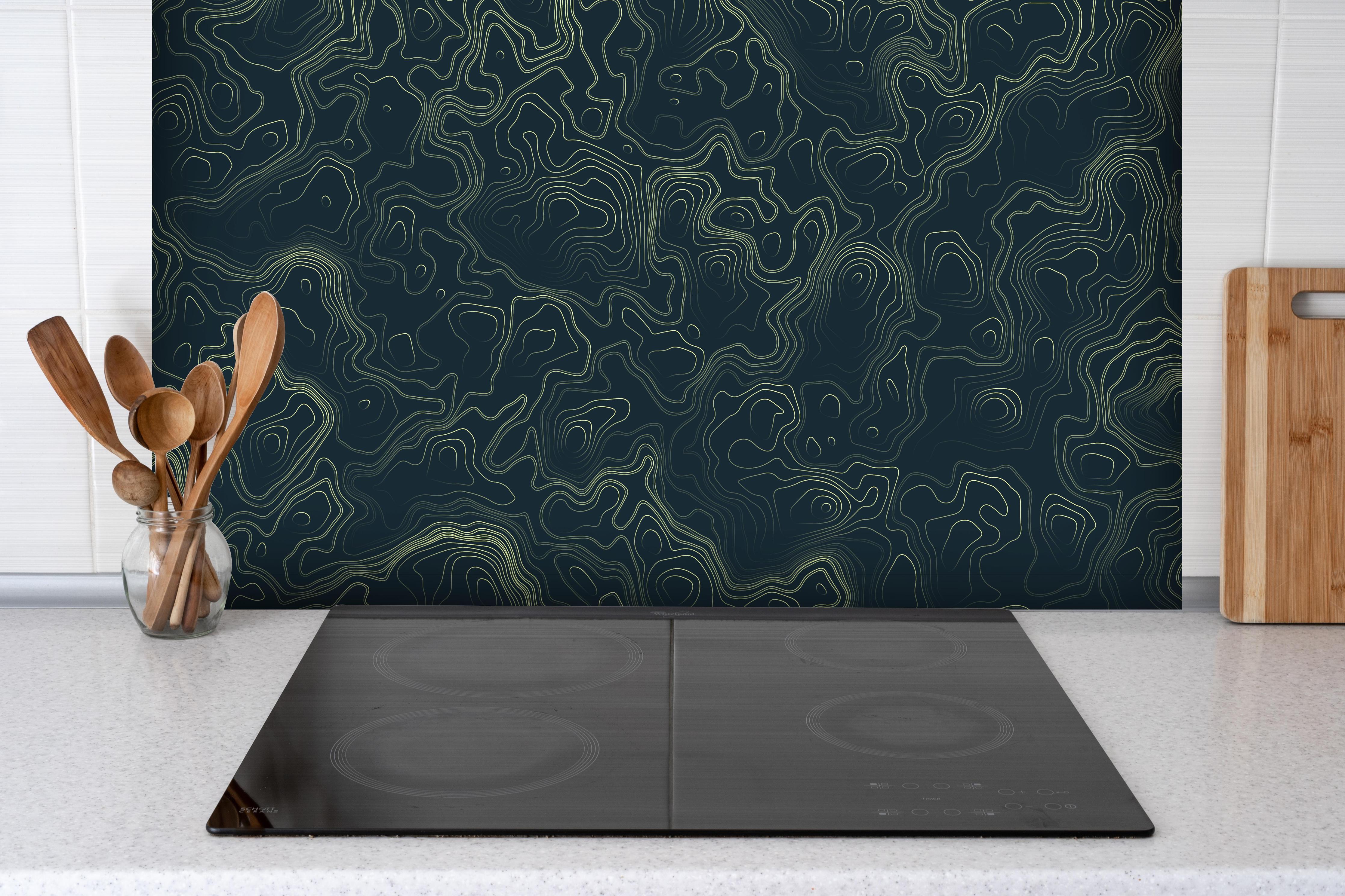 Spritzschutz - Abstraktes Muster auf gräulichem Hintergrund hinter einem Cerankochfeld zwischen Holz-Kochutensilien