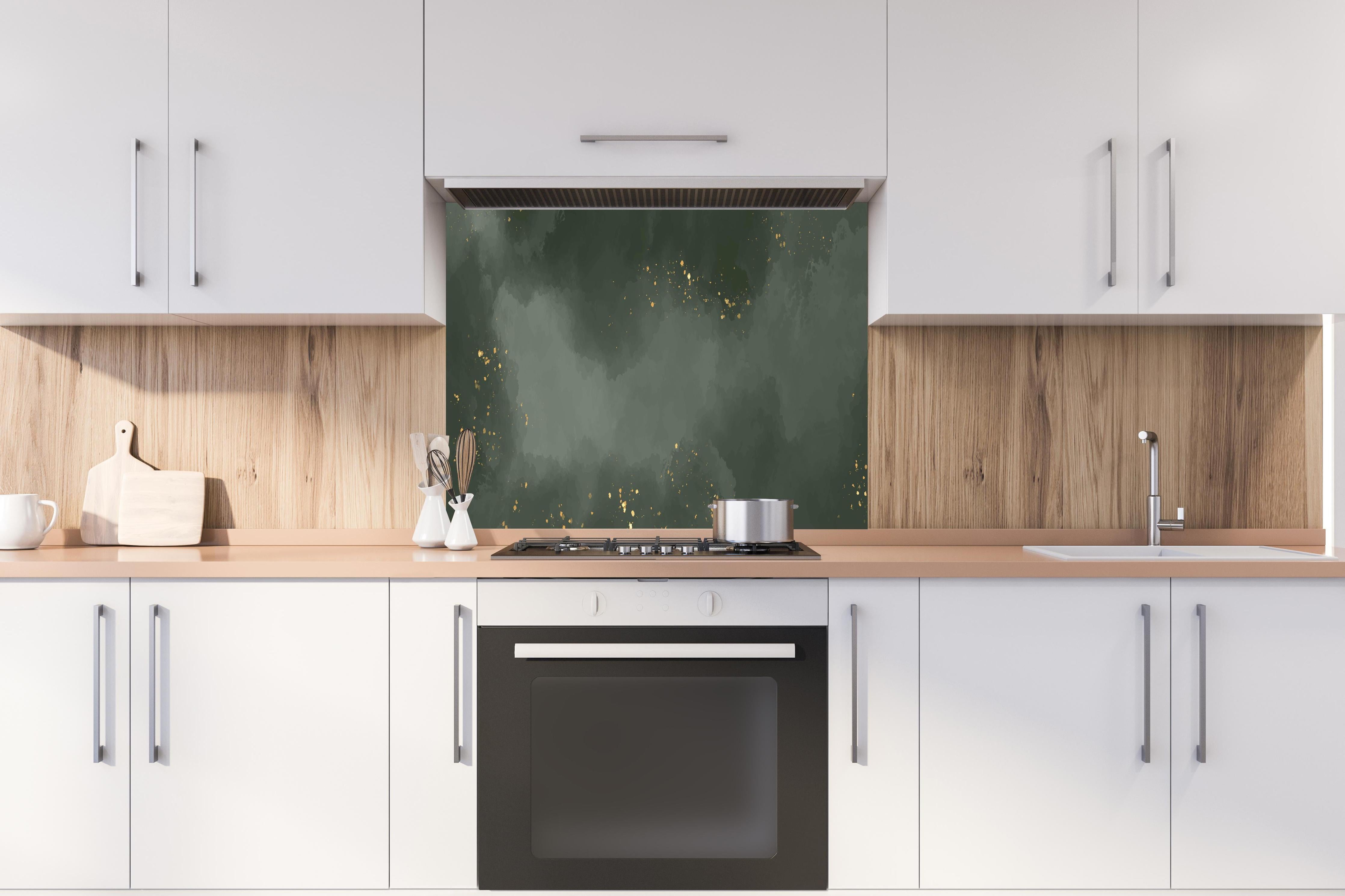 Spritzschutz - Abstraktes Muster in Dunkelgrün mit Gold hinter einem Cerankochfeld zwischen Holz-Kochutensilien