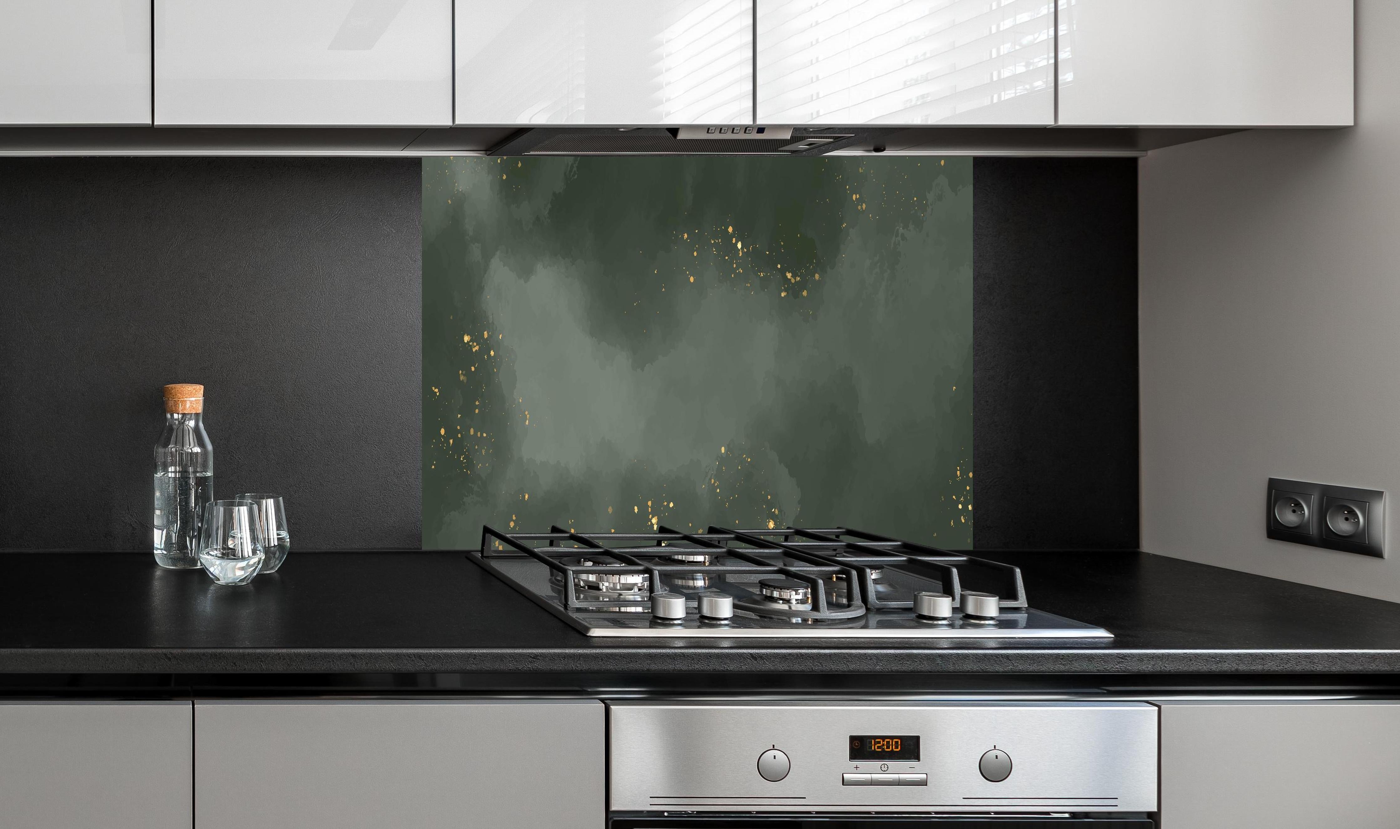Spritzschutz - Abstraktes Muster in Dunkelgrün mit Gold hinter einem Cerankochfeld zwischen Holz-Kochutensilien