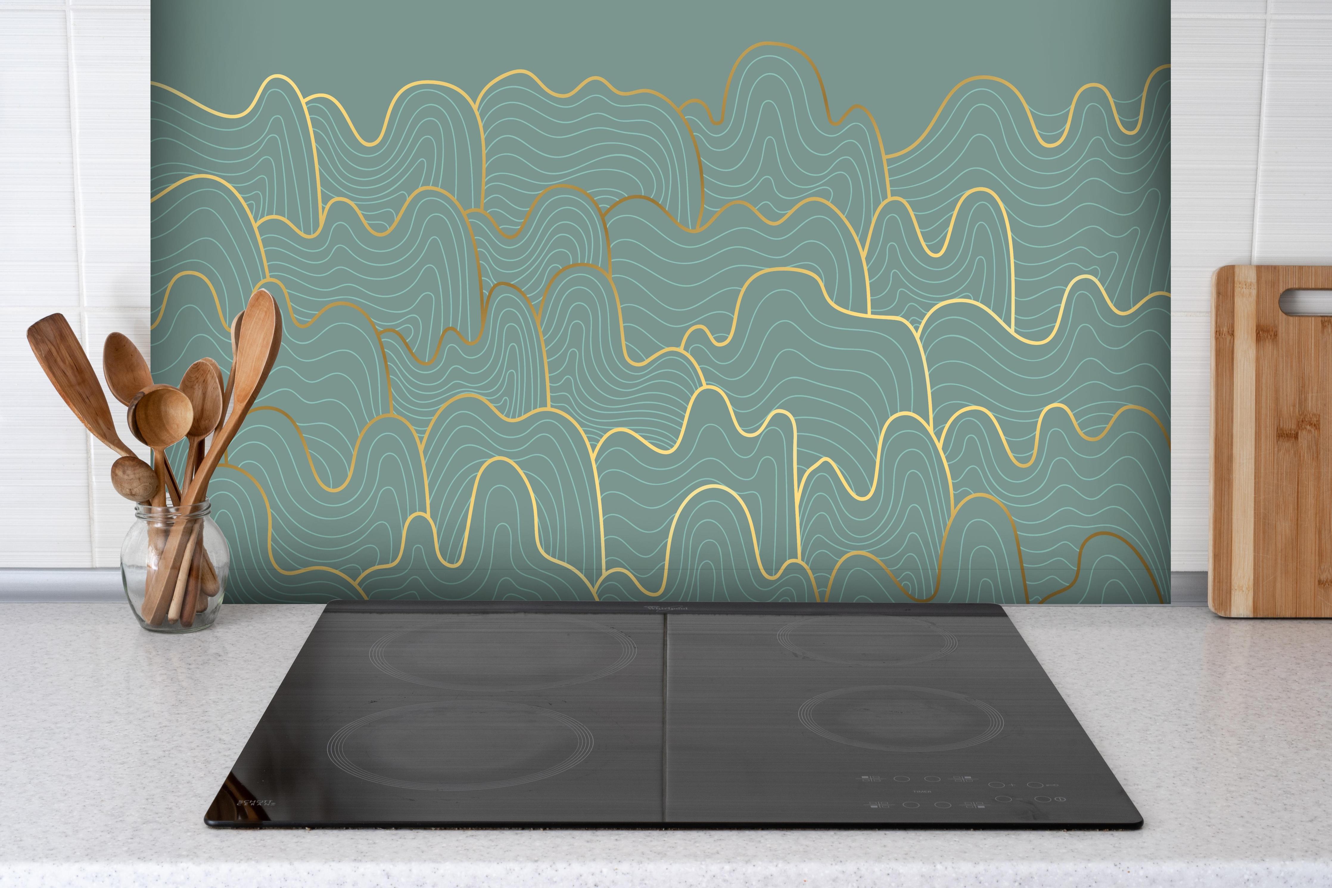 Spritzschutz - Abstraktes Wellendesign in Blau mit Goldenen Akzenten hinter einem Cerankochfeld zwischen Holz-Kochutensilien