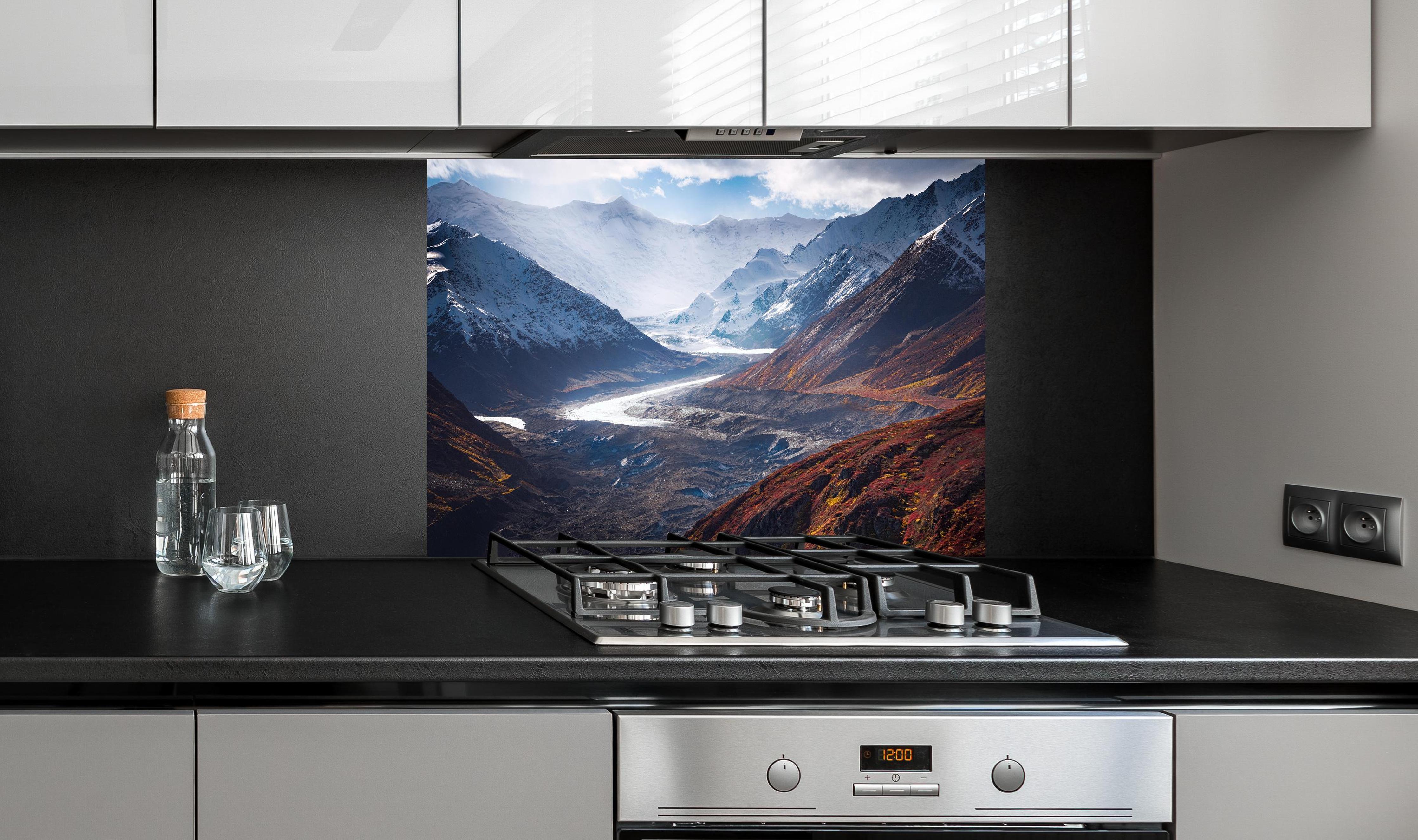 Spritzschutz - Alaska Herbst trifft Winter, Berglandschaft hinter einem Cerankochfeld zwischen Holz-Kochutensilien