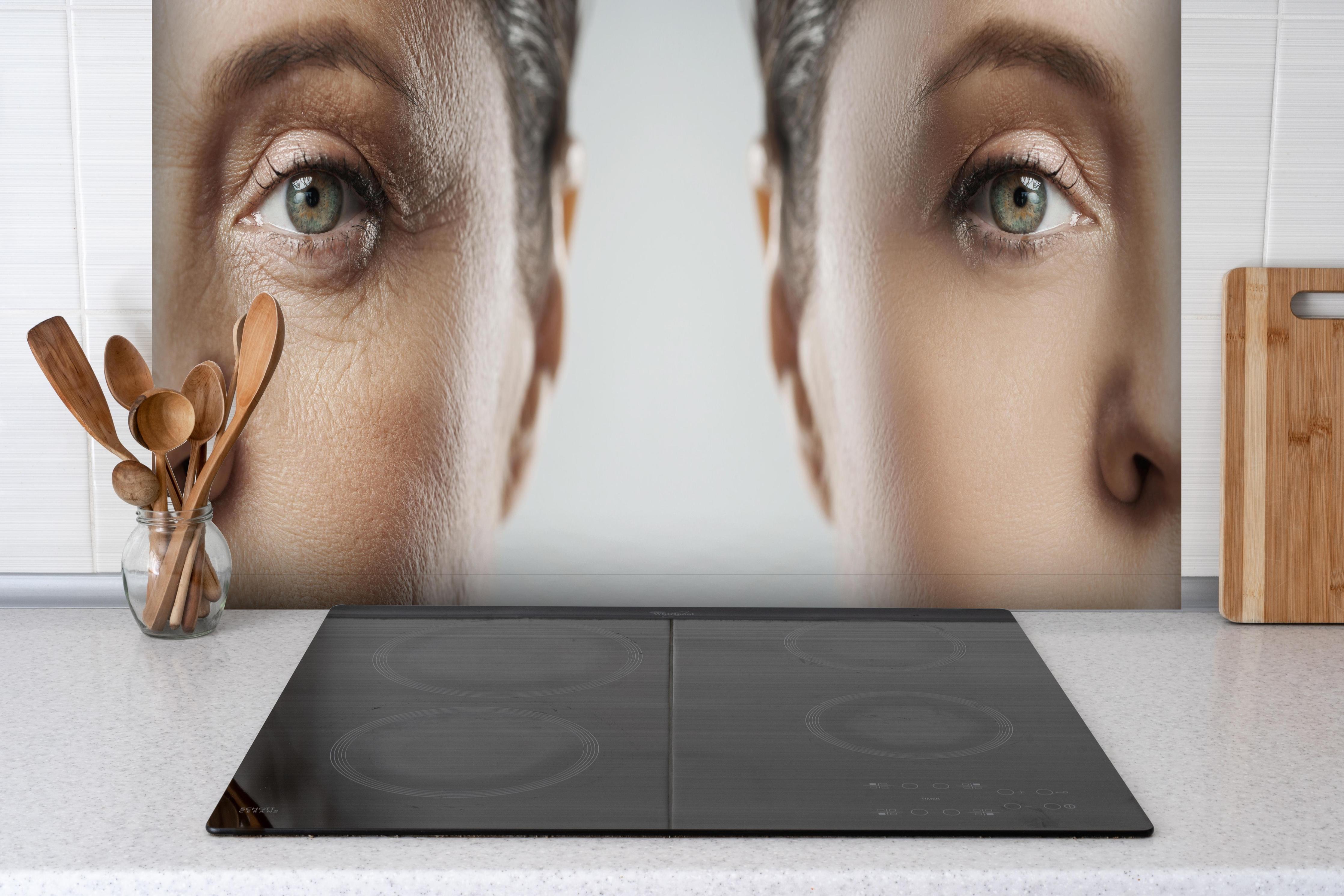 Spritzschutz - Alt und jung im Vergleich hinter einem Cerankochfeld zwischen Holz-Kochutensilien