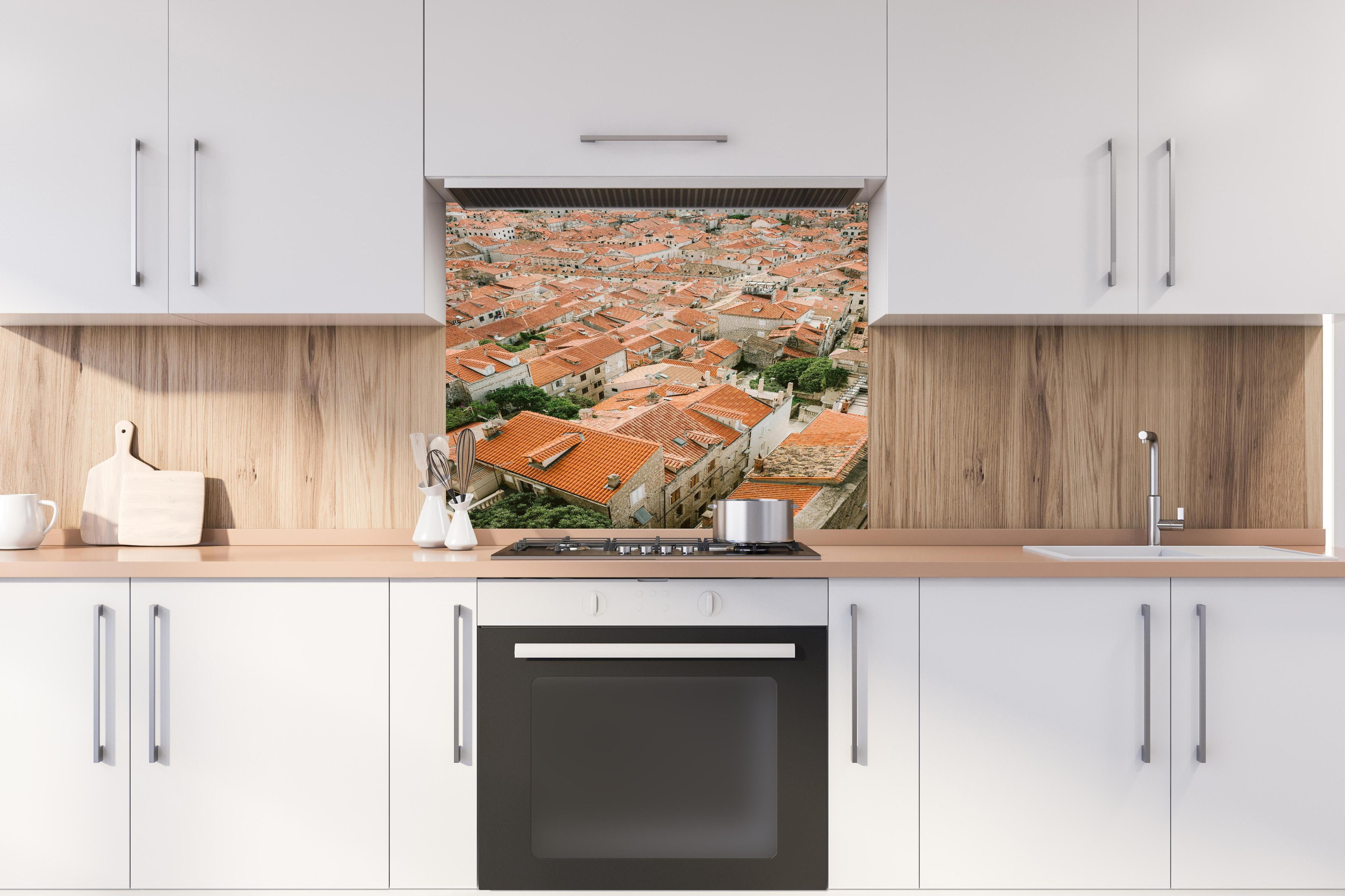 Spritzschutz - Alte Dachlandschaft Dubrovnik Kroatien hinter einem Cerankochfeld zwischen Holz-Kochutensilien