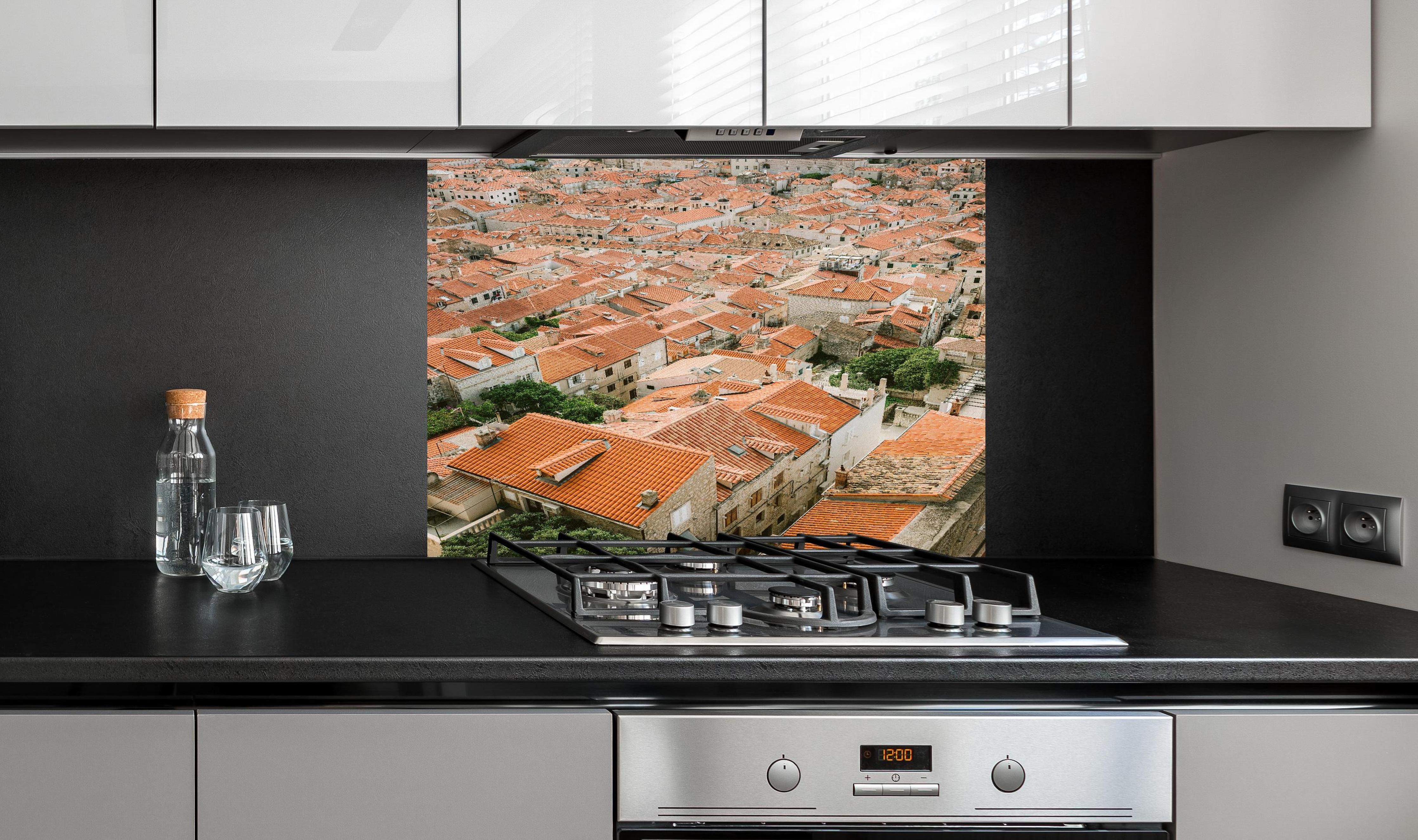 Spritzschutz - Alte Dachlandschaft Dubrovnik Kroatien hinter einem Cerankochfeld zwischen Holz-Kochutensilien