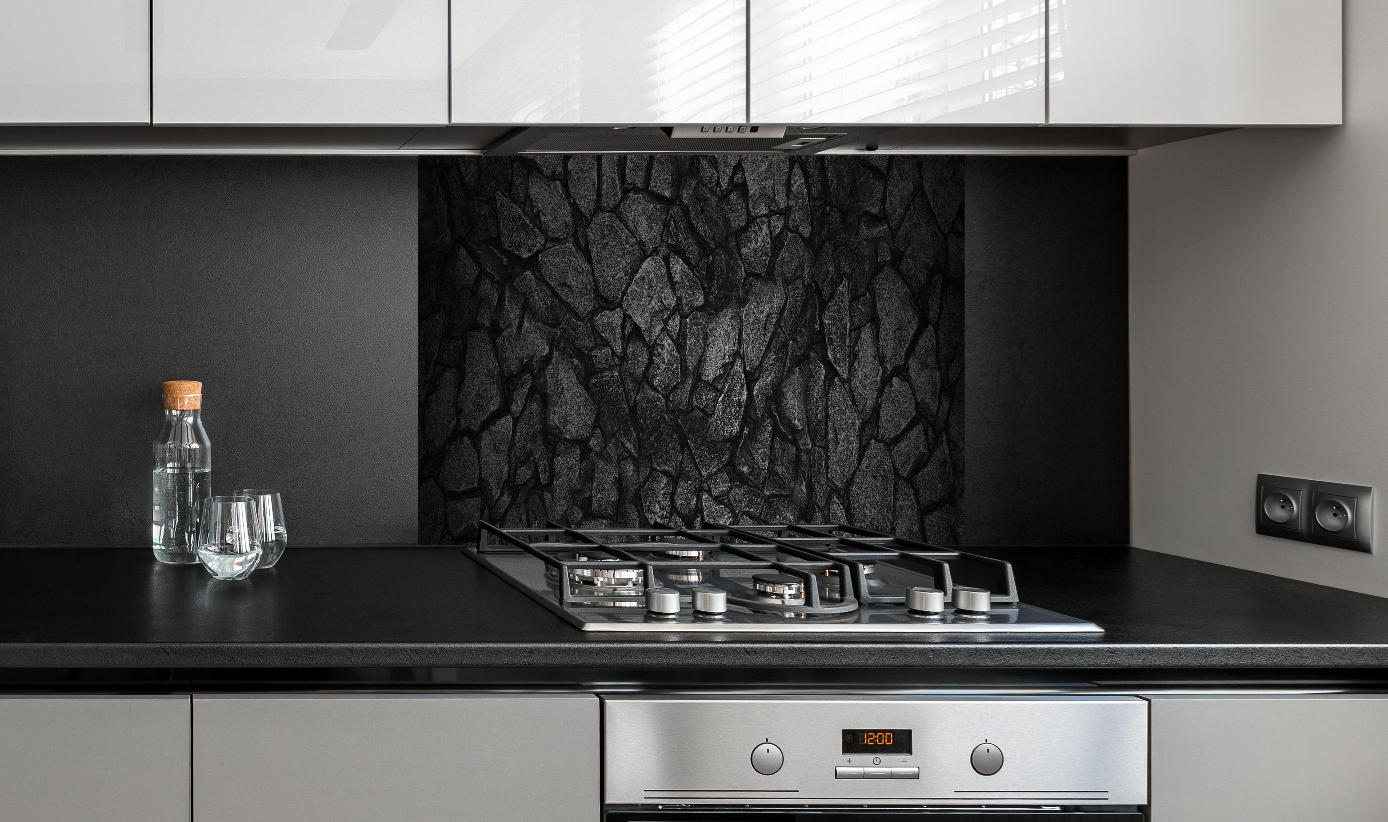 Spritzschutz - Alte Steinmauer - Hintergrund hinter einem Cerankochfeld zwischen Holz-Kochutensilien