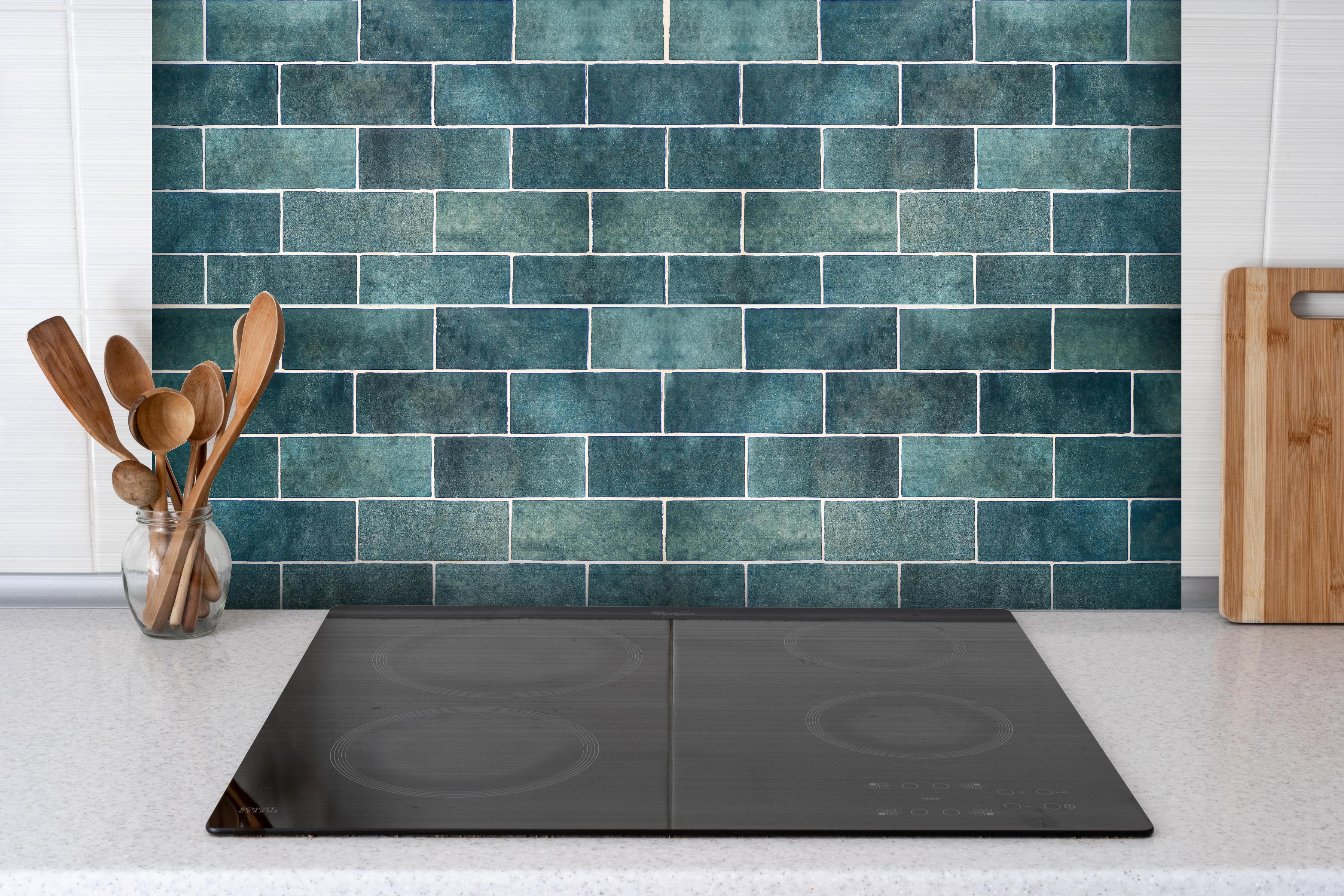 Spritzschutz - Alte Vintage Keramikfliesen in Blau hinter einem Cerankochfeld zwischen Holz-Kochutensilien