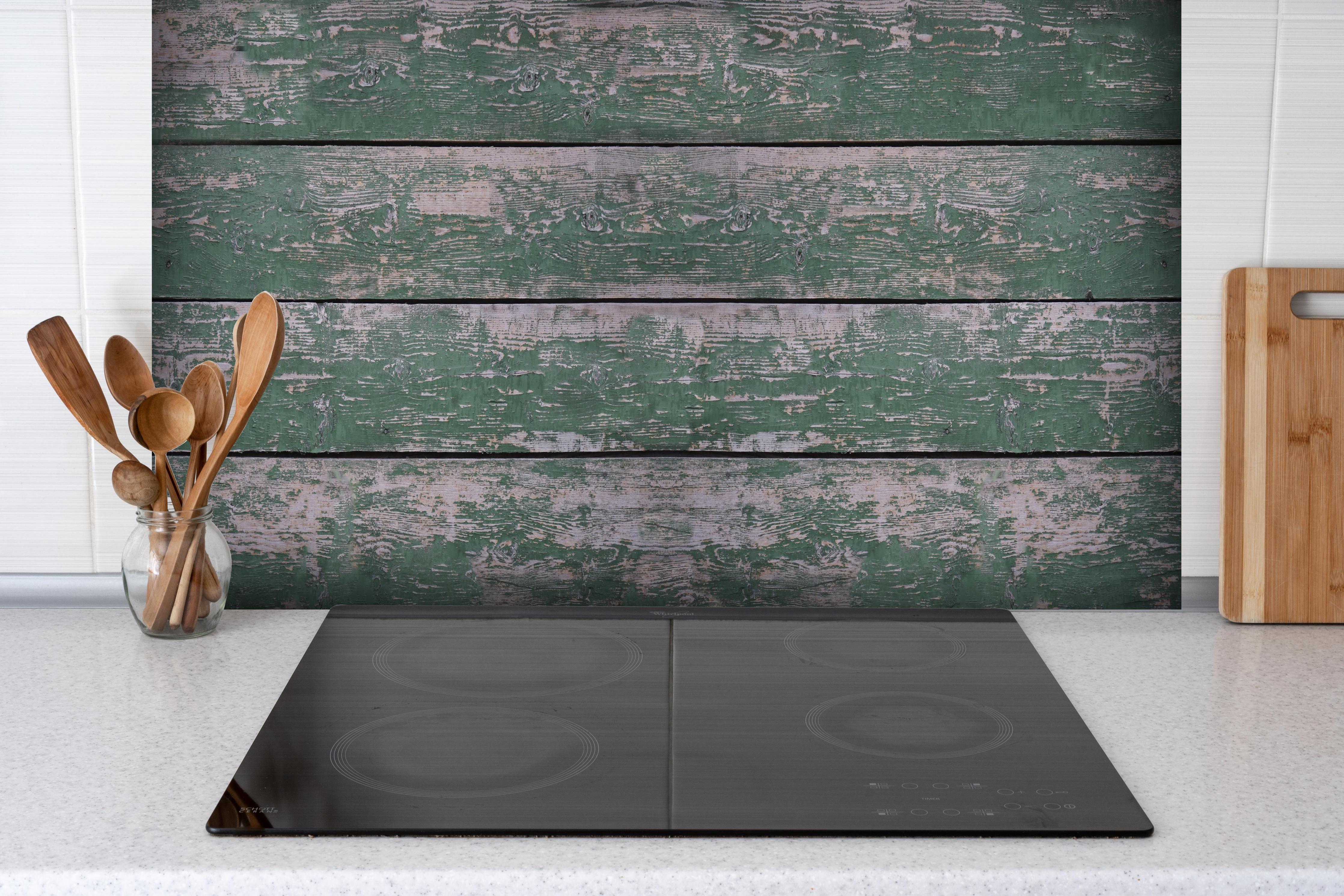 Spritzschutz - Alte grünliche Holztextur hinter einem Cerankochfeld zwischen Holz-Kochutensilien