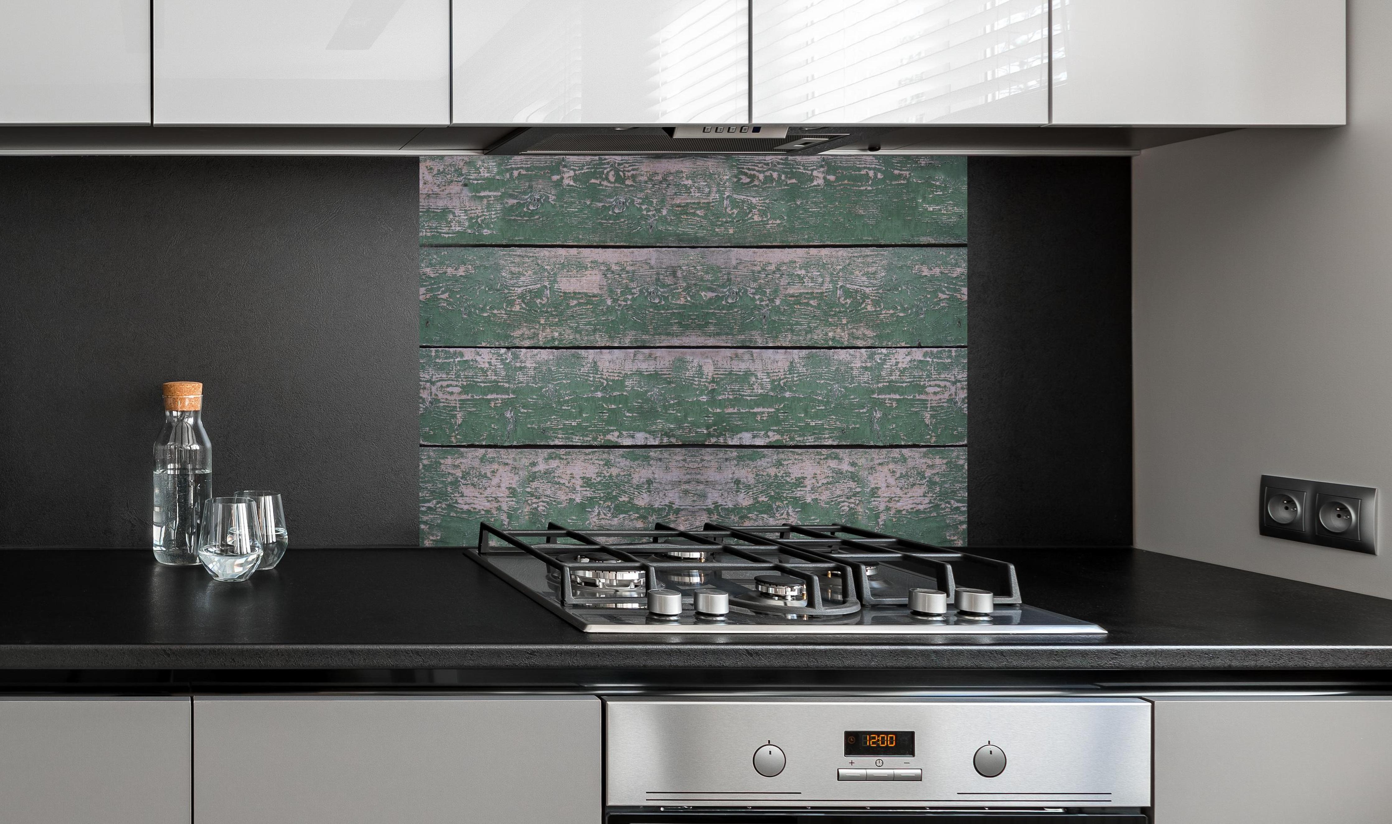 Spritzschutz - Alte grünliche Holztextur hinter einem Cerankochfeld zwischen Holz-Kochutensilien
