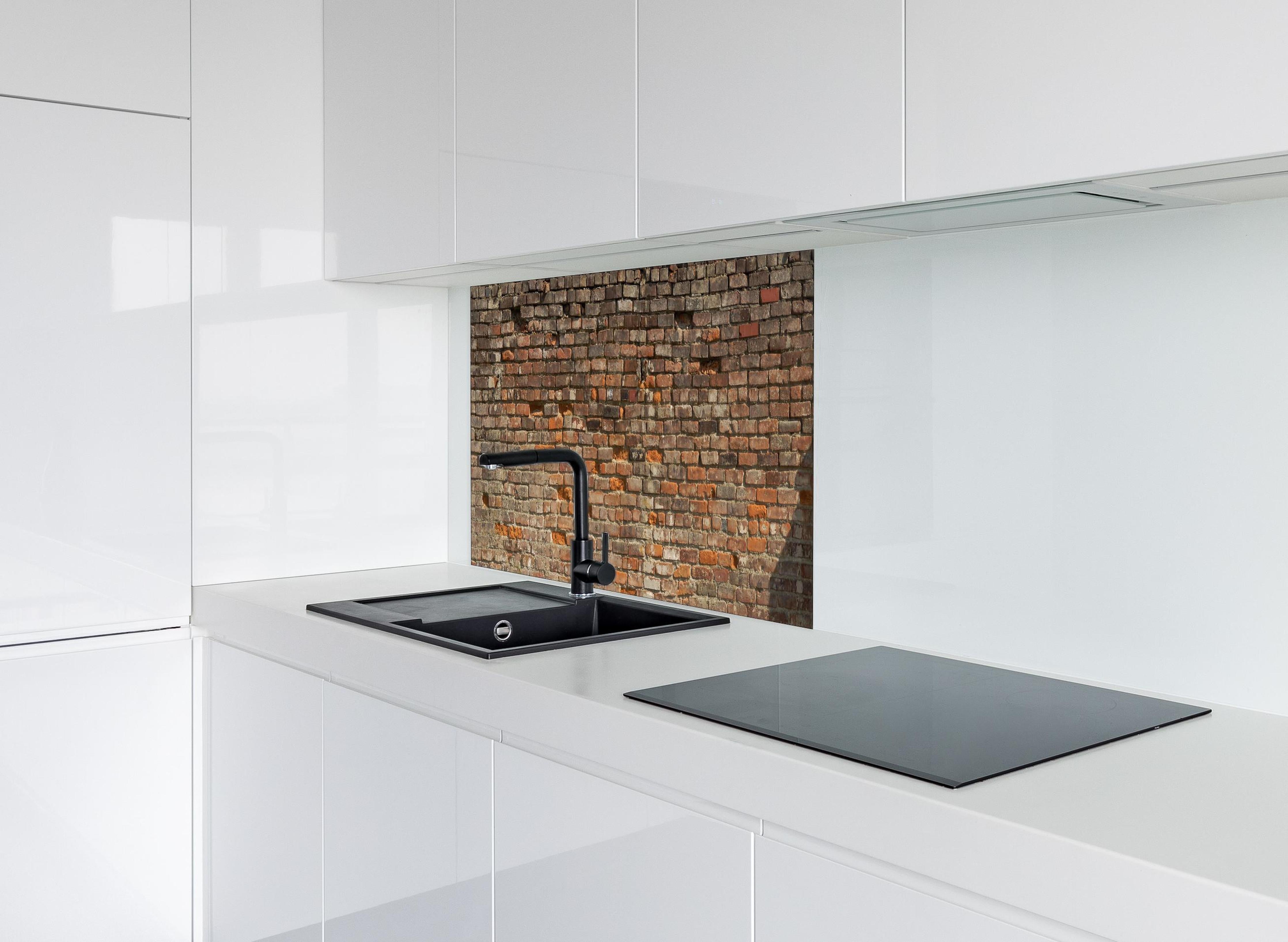 Spritzschutz - Alte kaputte Ziegelwand hinter einem Cerankochfeld zwischen Holz-Kochutensilien