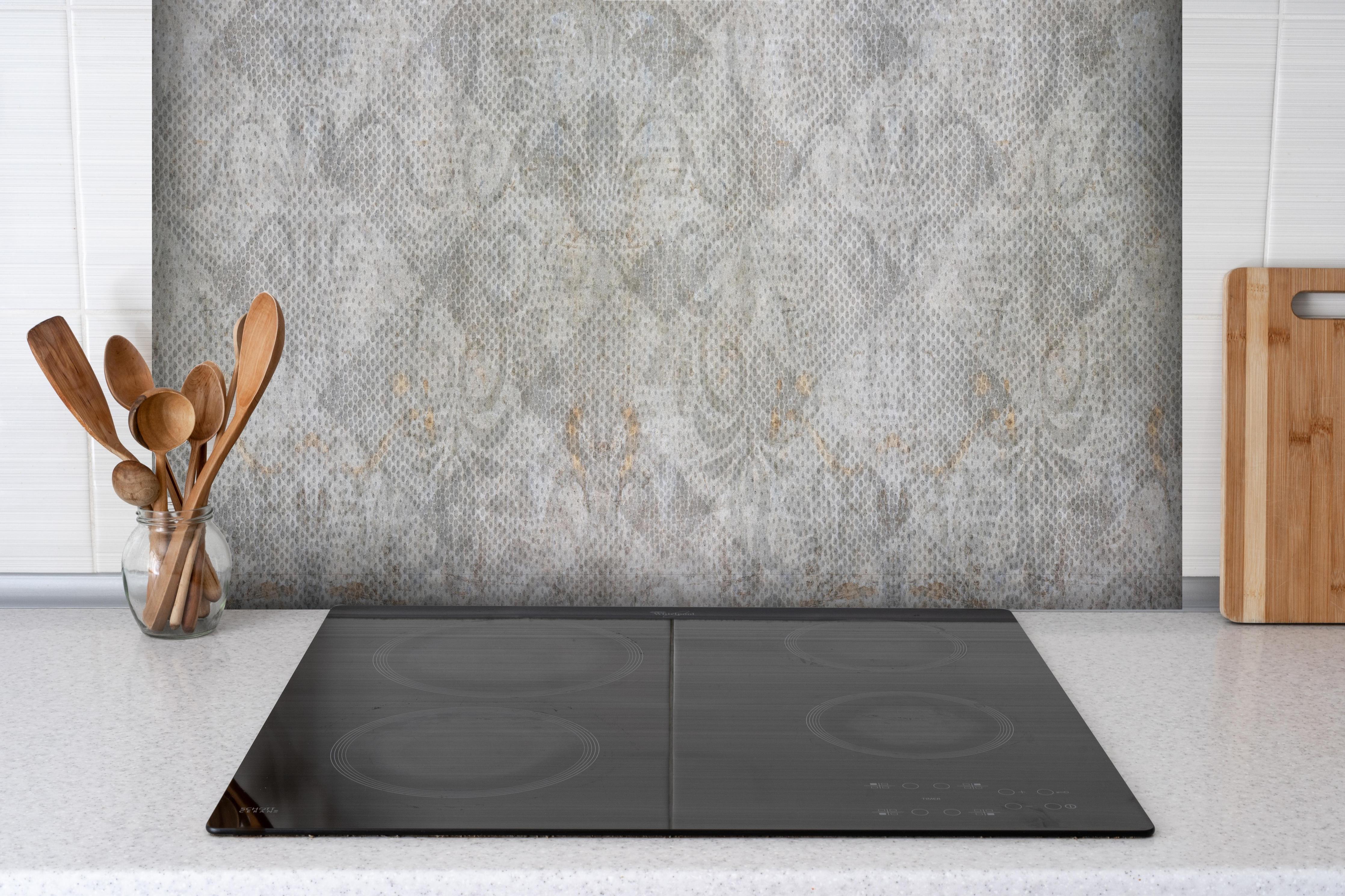 Spritzschutz - Alte weiße befleckte Tapete hinter einem Cerankochfeld zwischen Holz-Kochutensilien