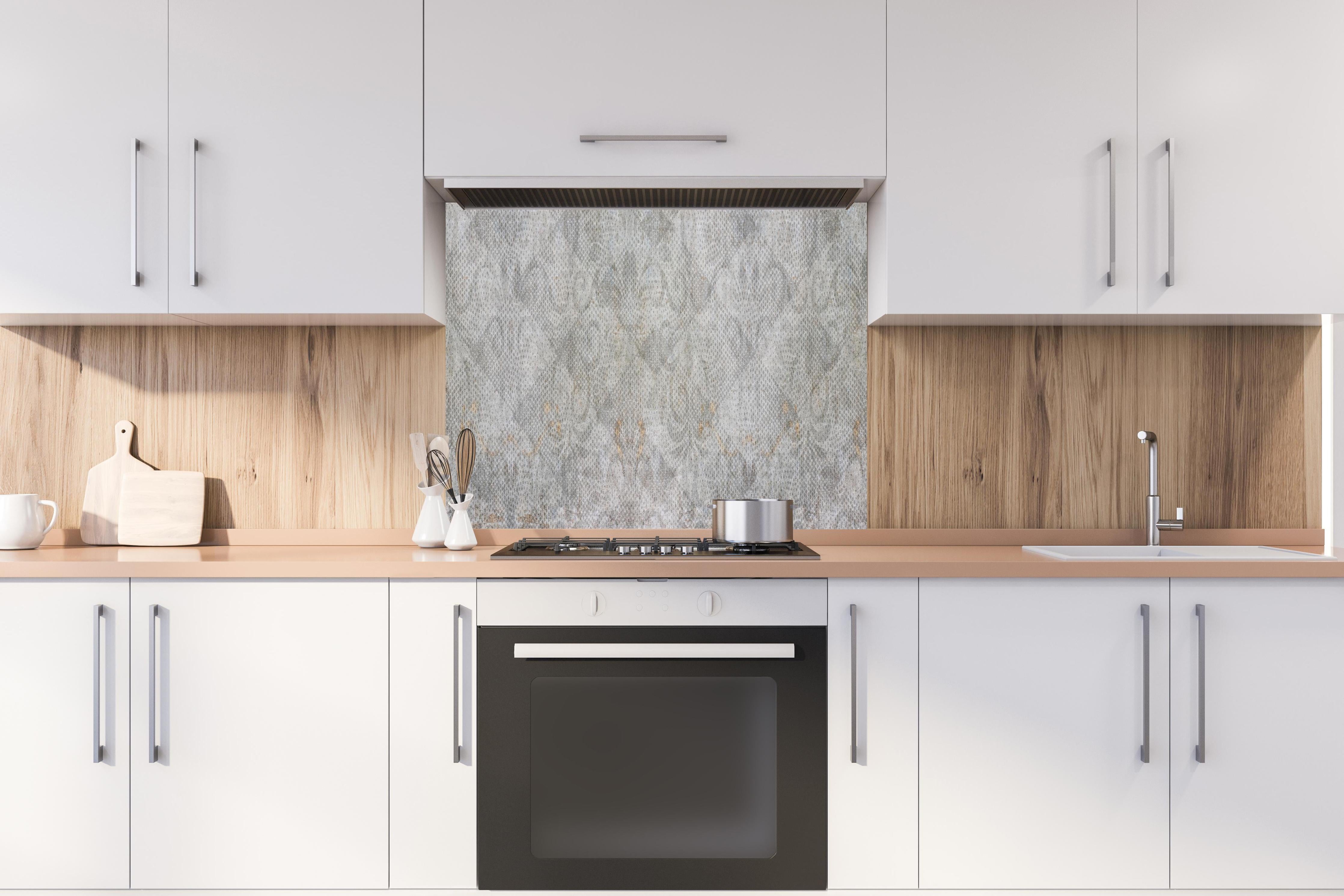 Spritzschutz - Alte weiße befleckte Tapete hinter einem Cerankochfeld zwischen Holz-Kochutensilien