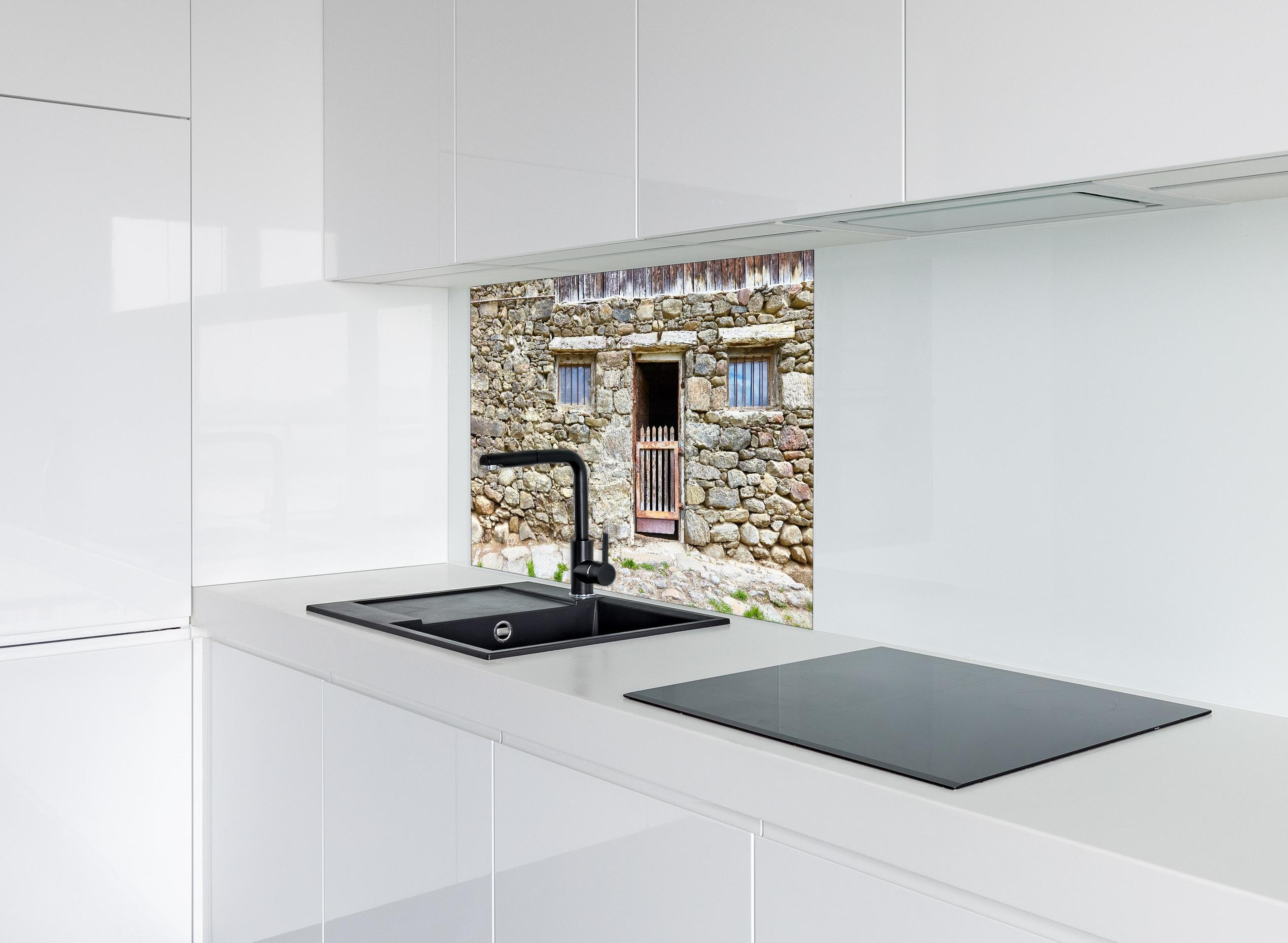 Spritzschutz - Alter Tierstall in Südtirol hinter einem Cerankochfeld zwischen Holz-Kochutensilien