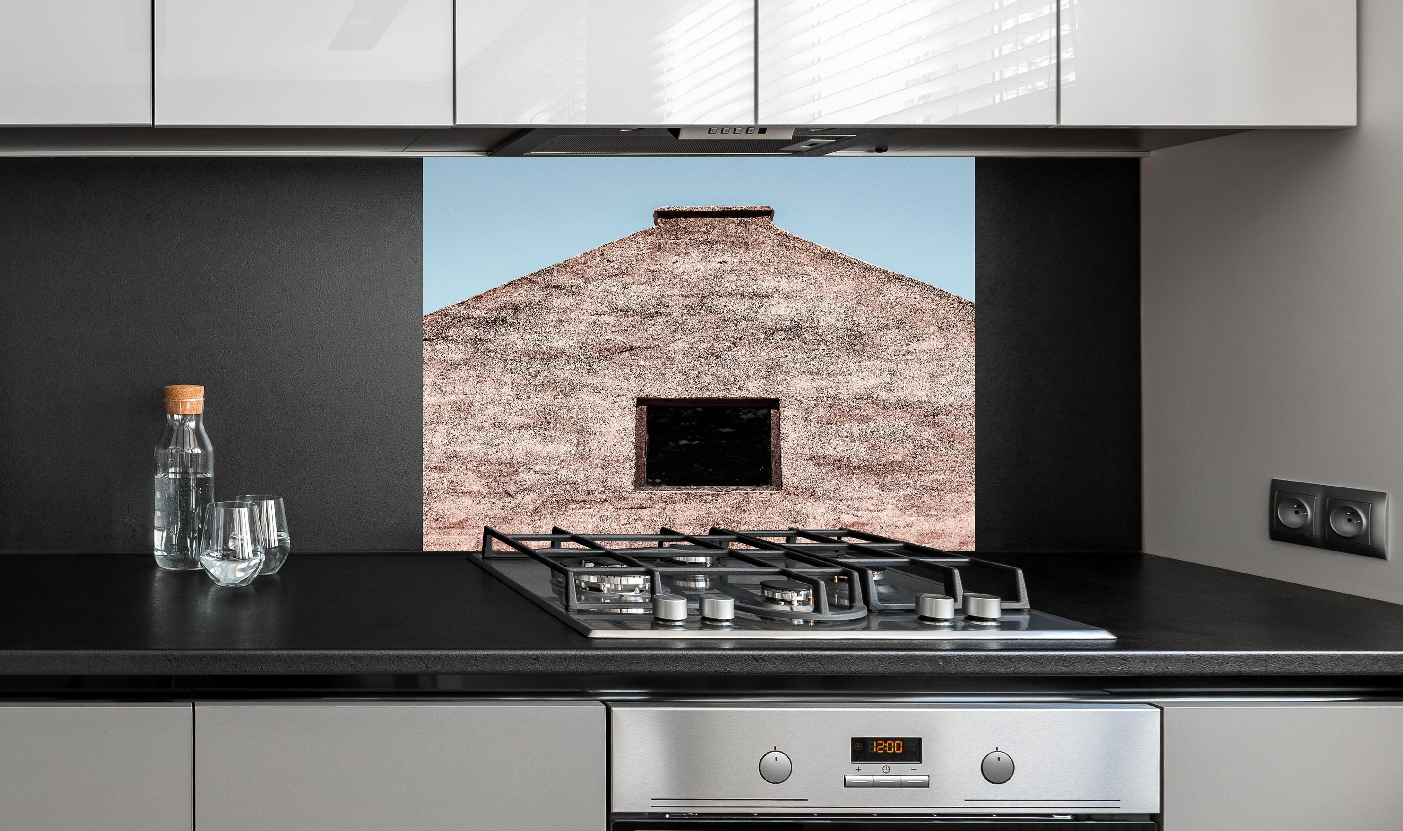 Spritzschutz - Altes Gebäude Fassade klarer Blauer Himmel hinter einem Cerankochfeld zwischen Holz-Kochutensilien